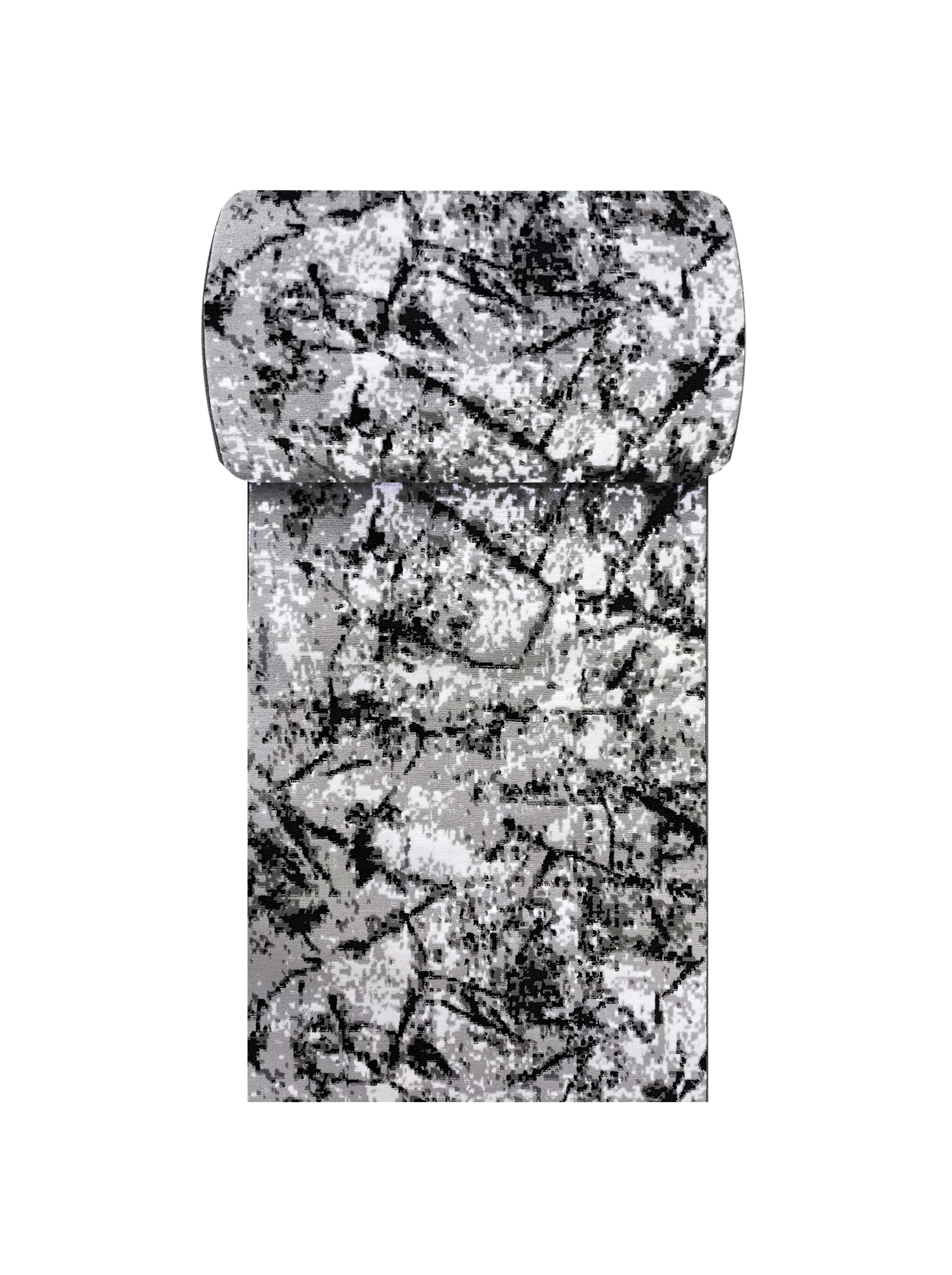 Tapis rectangulaire avec un motif abstrait de tons gris et noirs sur fond blanc, partiellement roulé