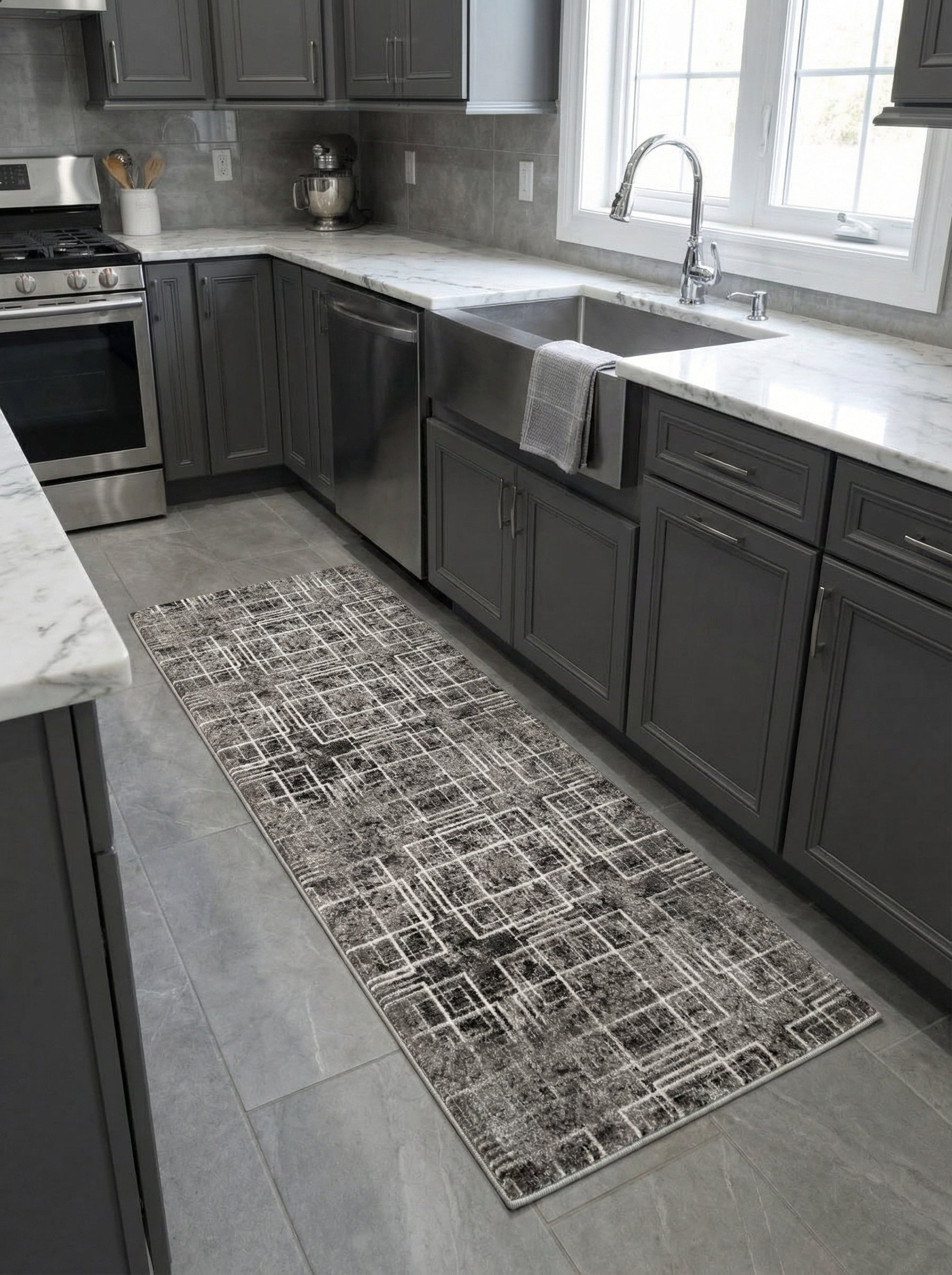 Tapis de couloir gris foncé, noir et blanc, à motifs géométriques de lignes entrelacées, sur un sol carrelé dans une cuisine moderne