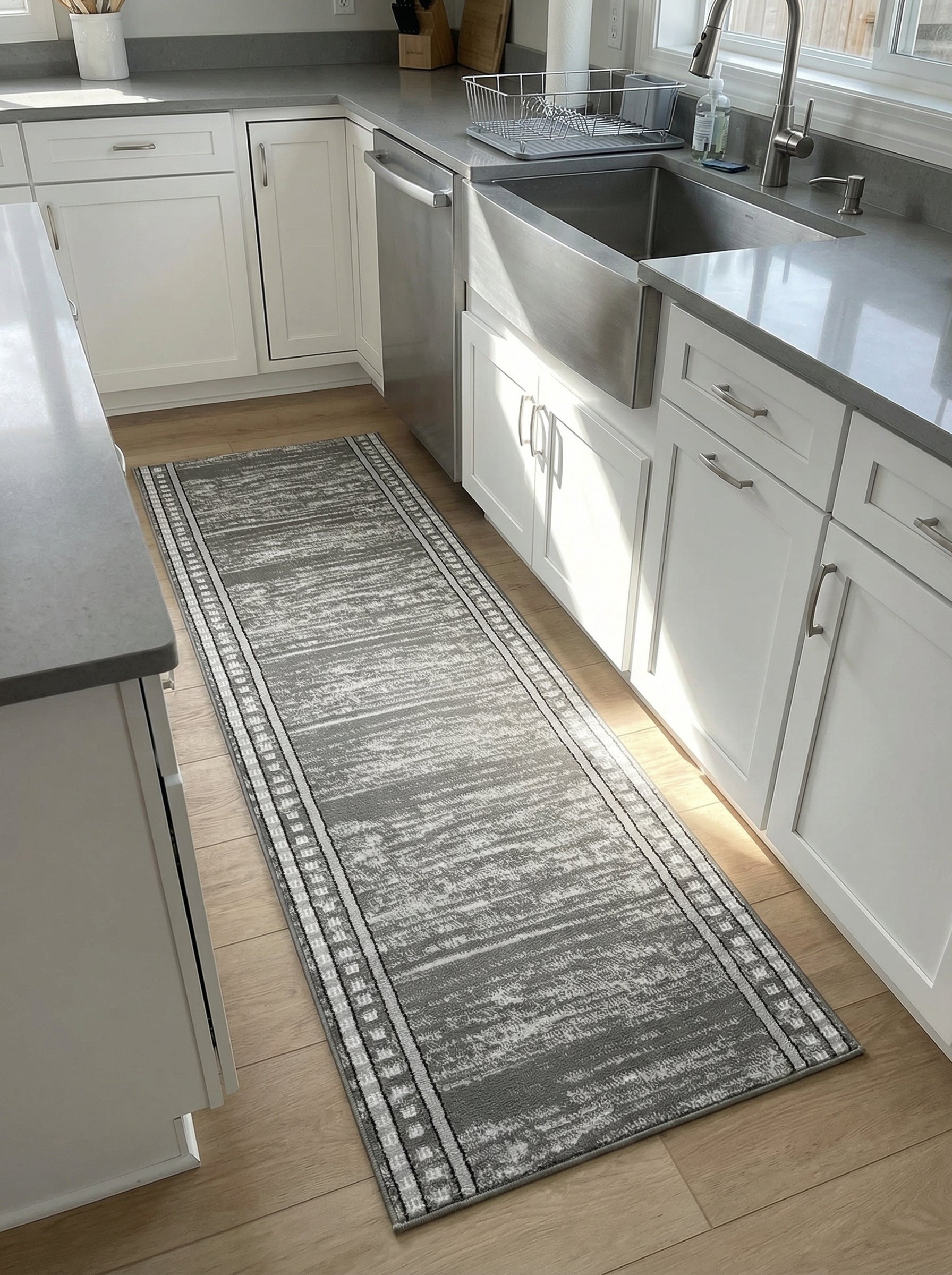 Tapis de couloir gris et blanc à motifs abstraits et bordures géométriques, sur un plancher en bois clair dans une cuisine