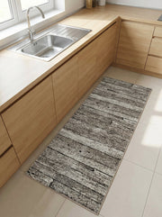 Tapis rectangulaire gris, blanc et noir à motifs planches de bois usées, posé sur un carrelage clair dans une cuisine moderne