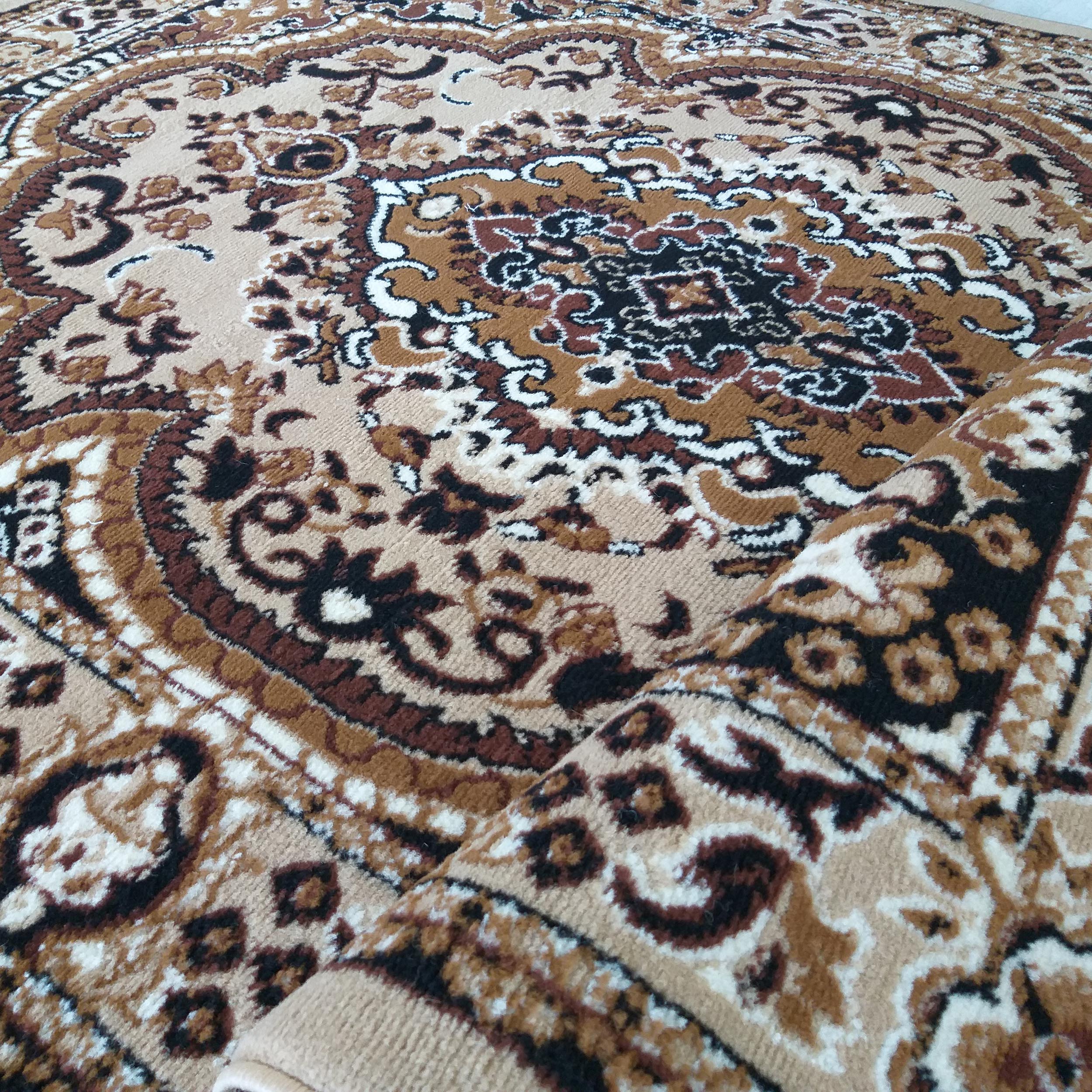 Tapis enroulé avec des motifs floraux et ornementaux complexes dans des tons de beige, marron, noir et crème