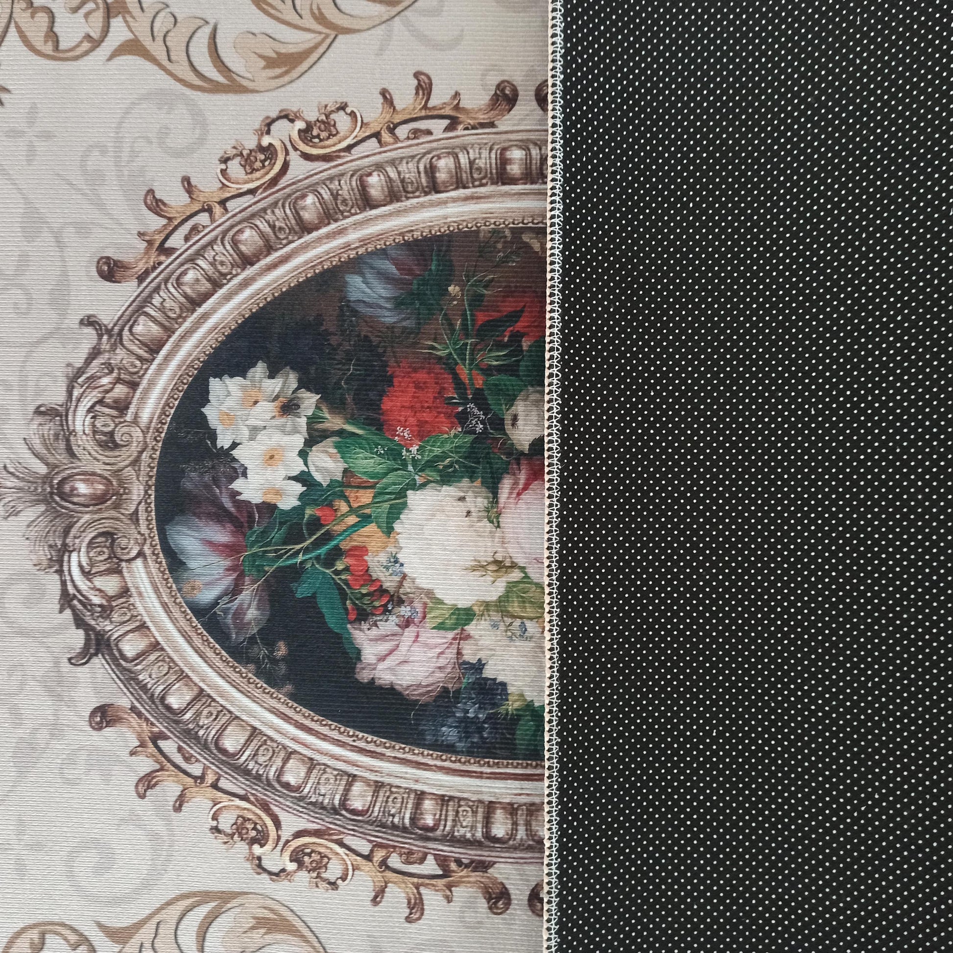 Tapis orné d'un motif baroque doré avec des fleurs colorées sur fond beige à volutes. L'envers est noir à pois blancs