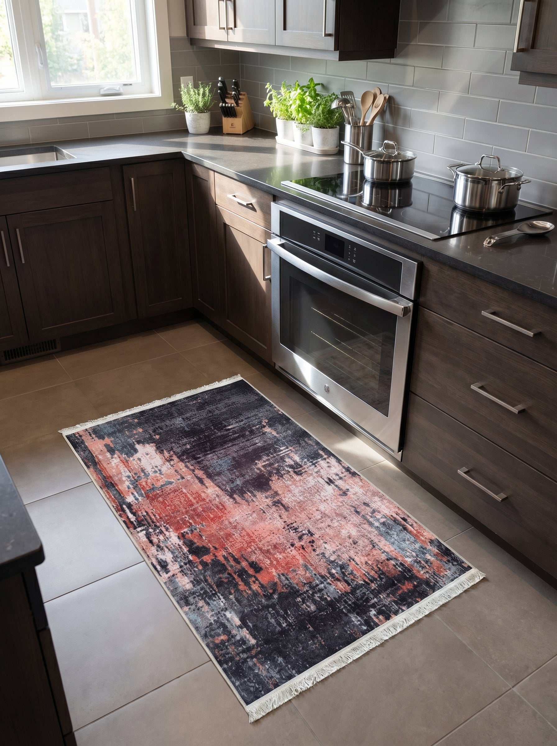 Tapis rectangulaire abstrait gris foncé, corail et bleu clair, à franges, sur le carrelage d'une cuisine moderne