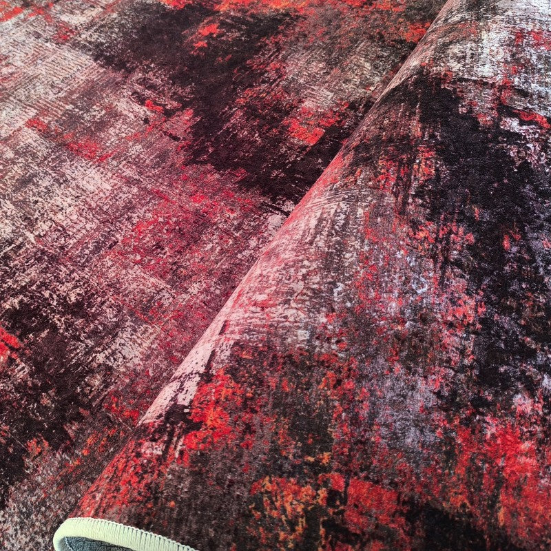 Tapis à motifs abstraits et effet vieilli, mélange de teintes rouge, noir et blanc, avec un aspect textile doux