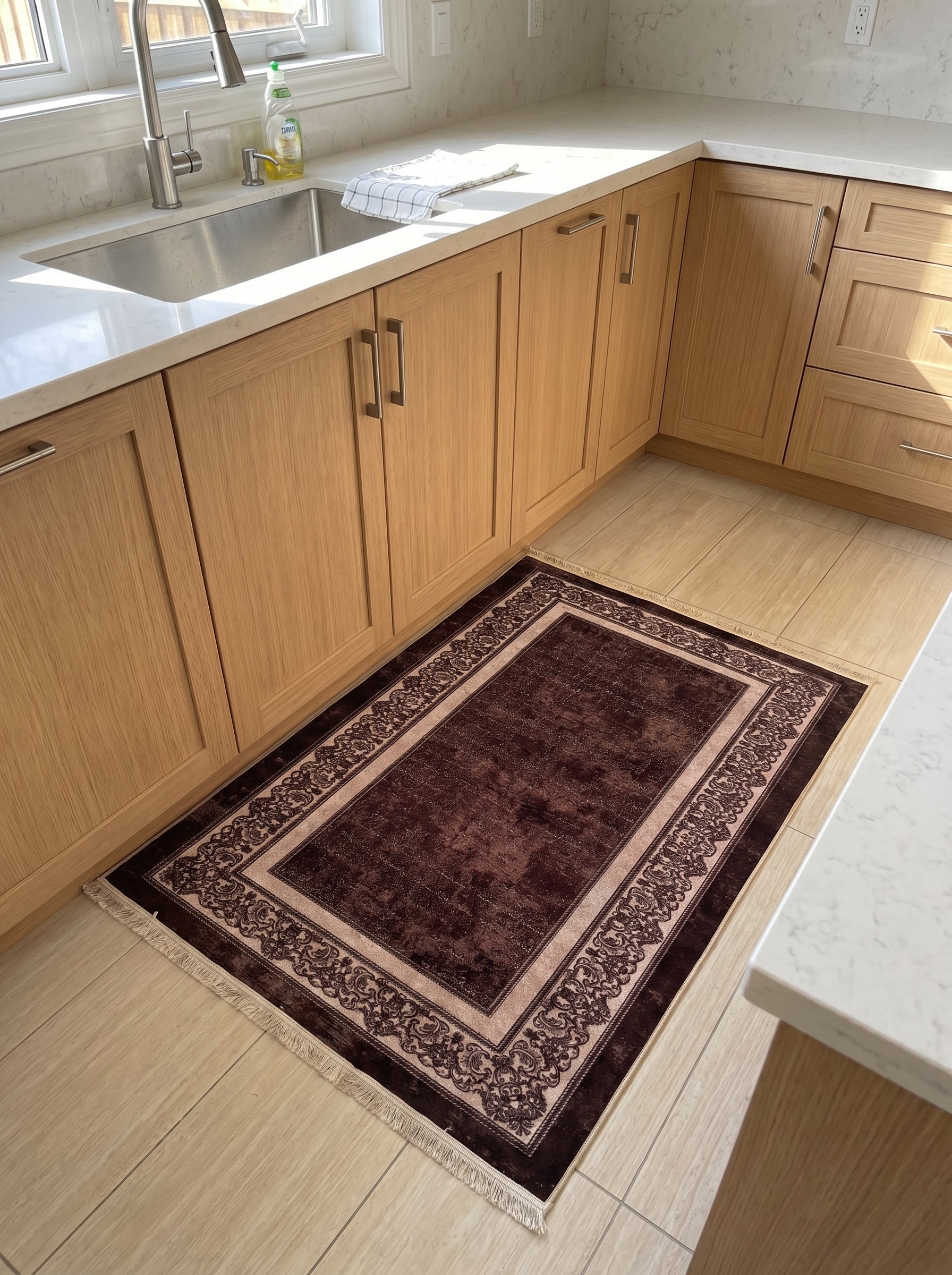 Tapis rectangulaire marron foncé à motifs floraux beiges et bruns sur les bordures, posé sur un sol carrelé dans une cuisine moderne