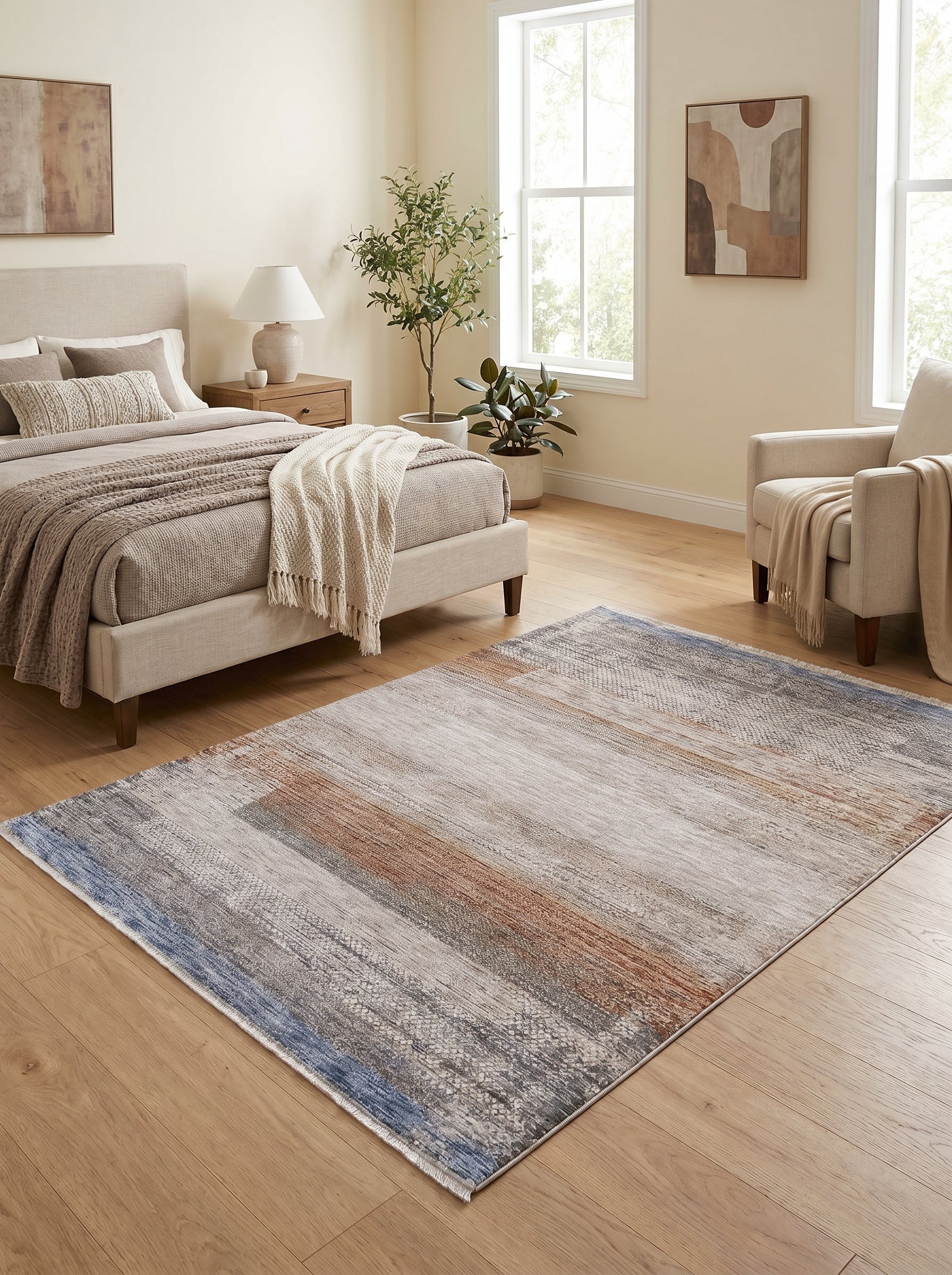 Tapis rectangulaire aux motifs abstraits bleus, terre cuite, gris et beige clair dans une chambre
