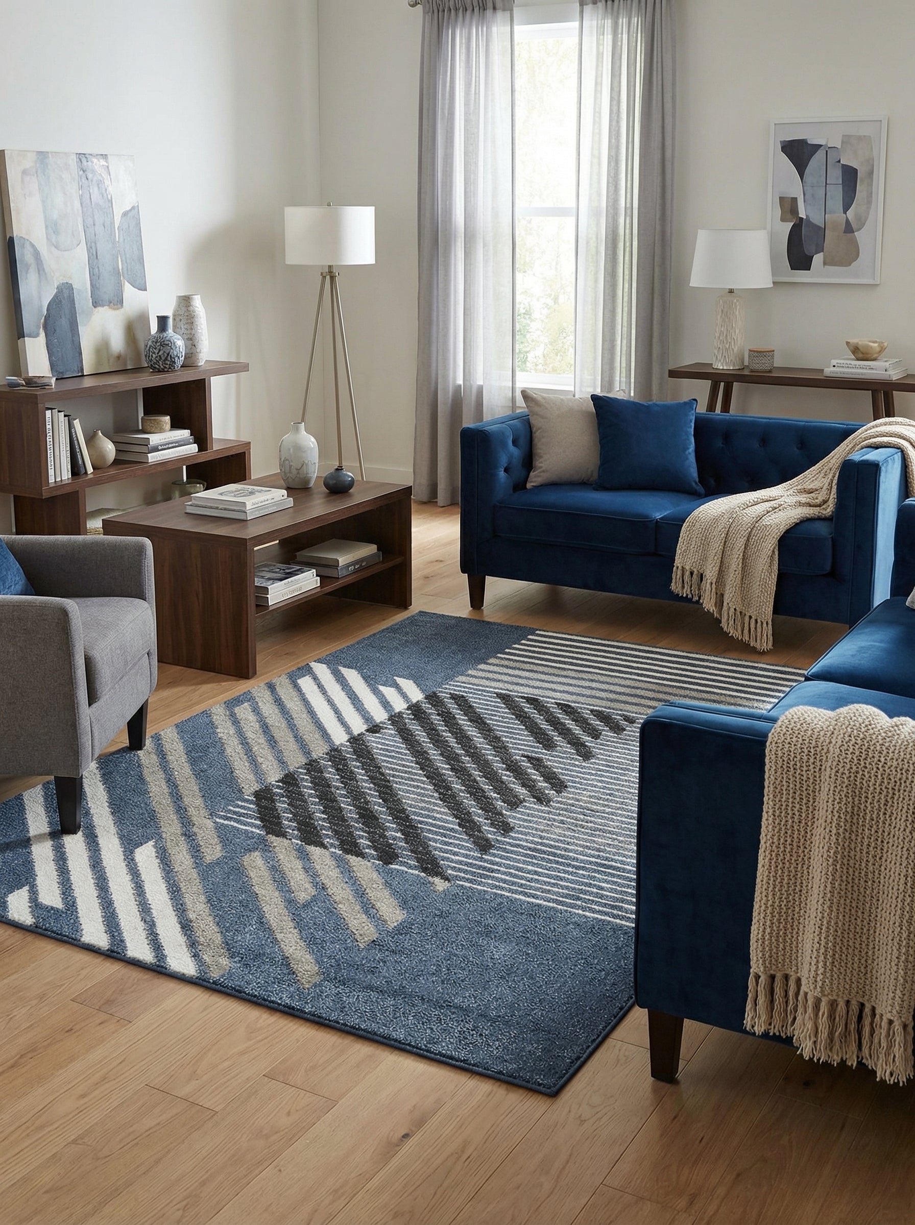 Tapis rectangulaire moderne bleu, gris, blanc et noir avec des motifs géométriques de lignes et blocs obliques et horizontaux, posé dans un salon décoré