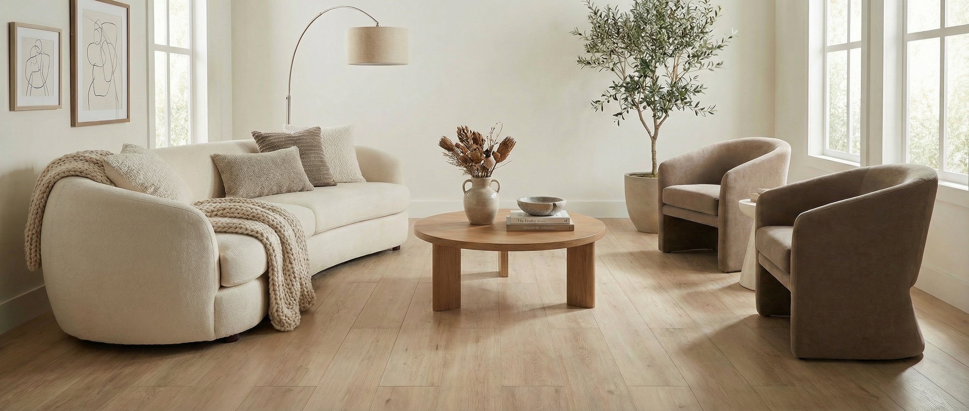 Pièce beige, sans tapis, avec canapé et fauteuils. Sol en bois clair. Table ronde. Espace à transformer