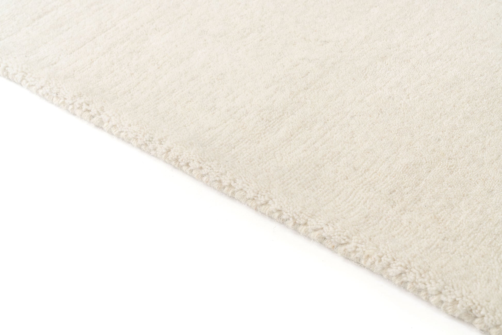 Tapis dense et moelleux, couleur ivoire, pour un confort optimal dans une pièce. Type tapis