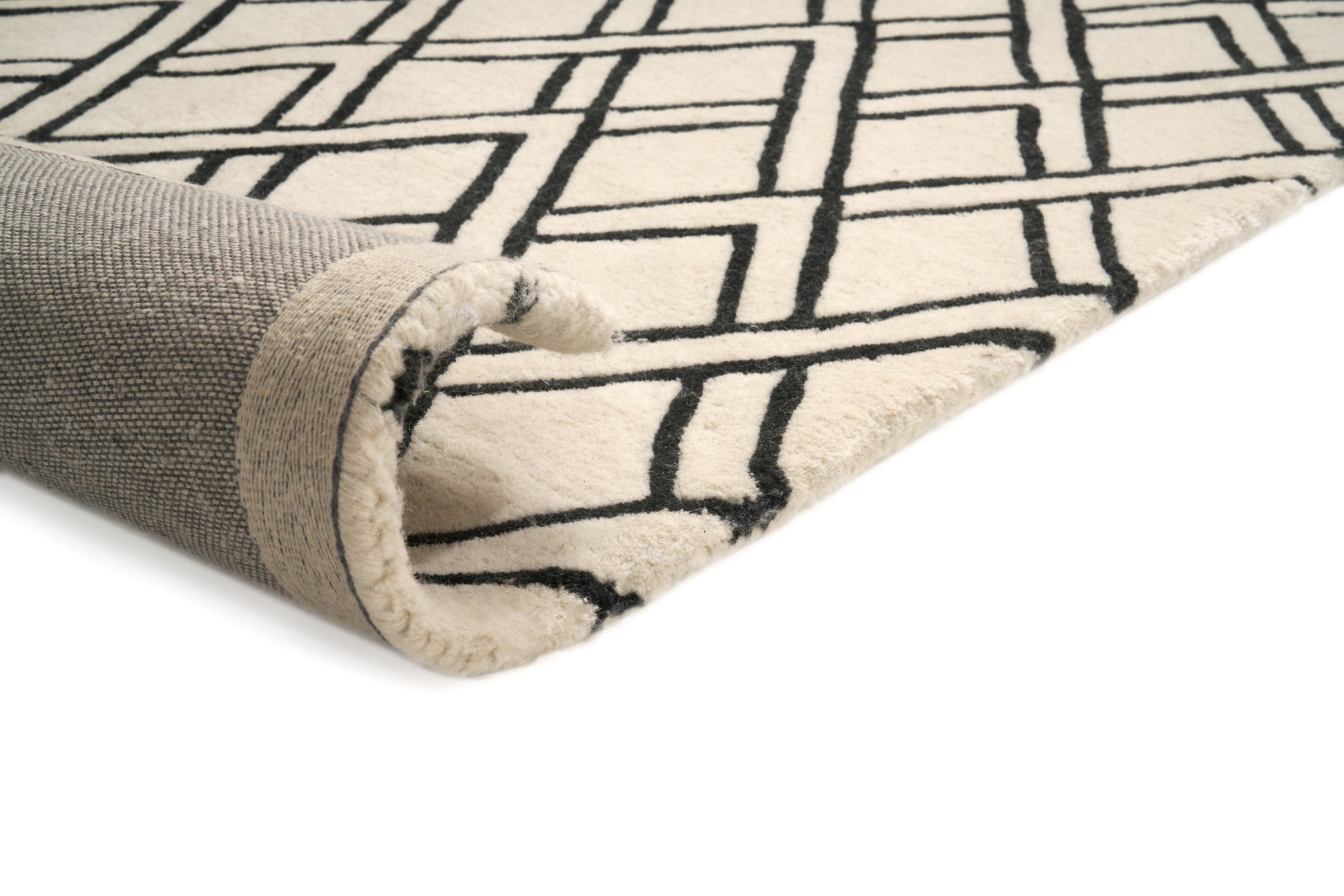 Bordure de tapis avec envers gris et finitions beiges. Motif géométrique noir sur fond ivoire