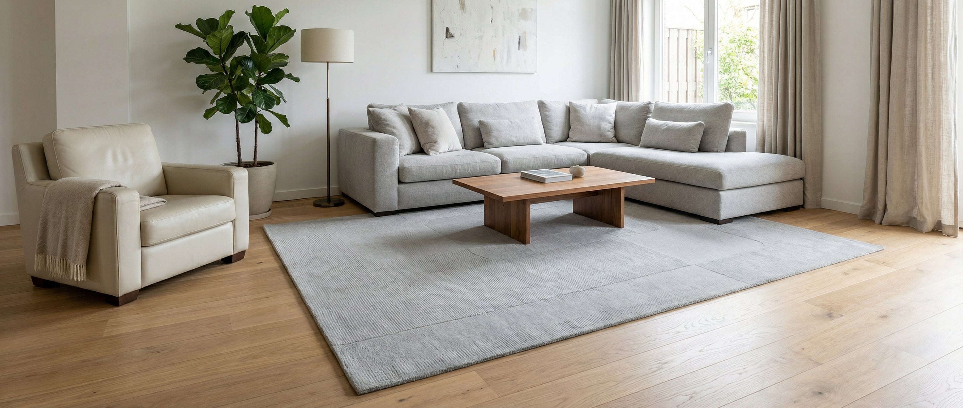 Un tapis gris rectangulaire transforme la pièce, créant une harmonie avec le mobilier et l'ambiance générale