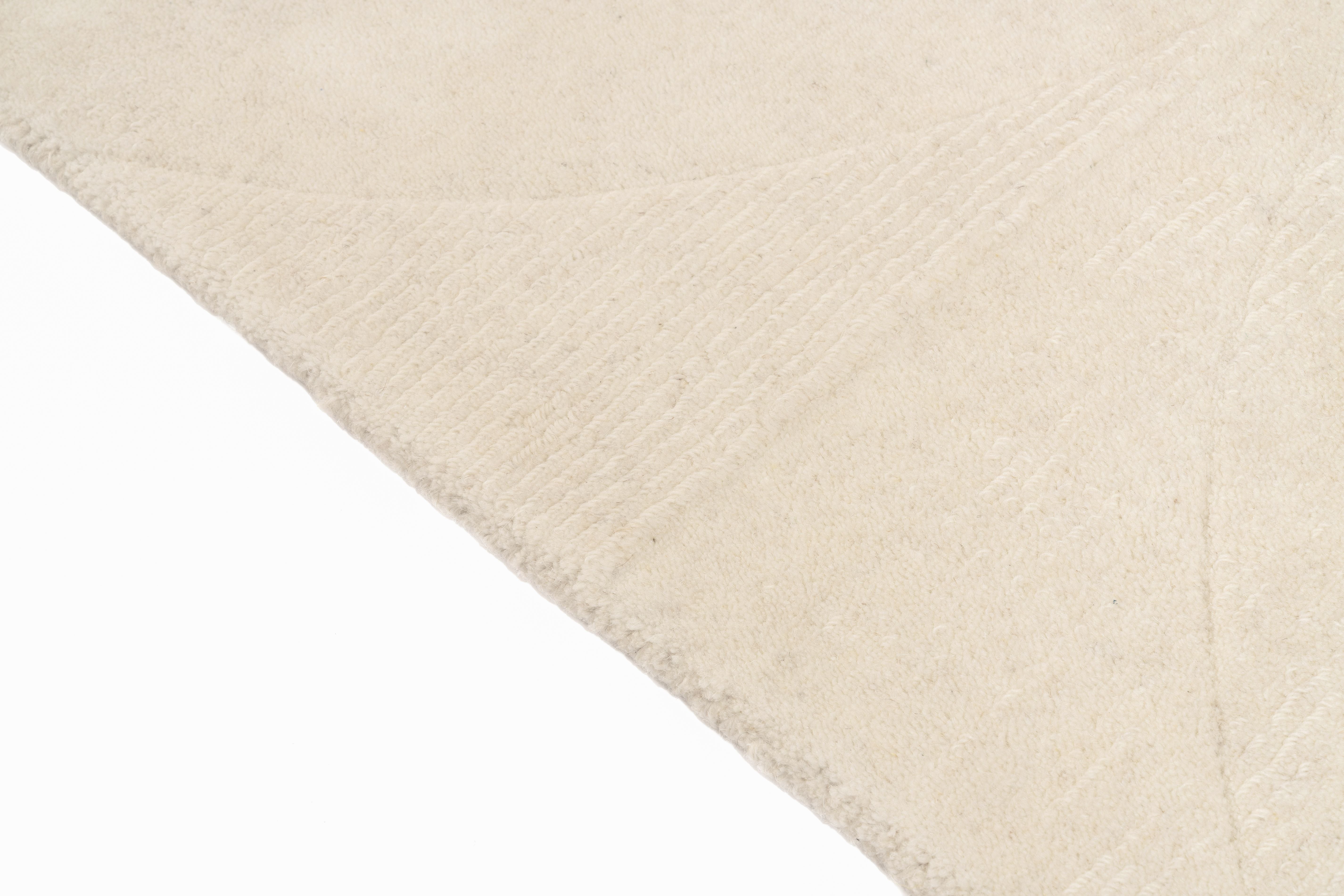 Tapis rectangulaire ivoire. Tissage texturé avec relief. Aspect tactile doux et moelleux