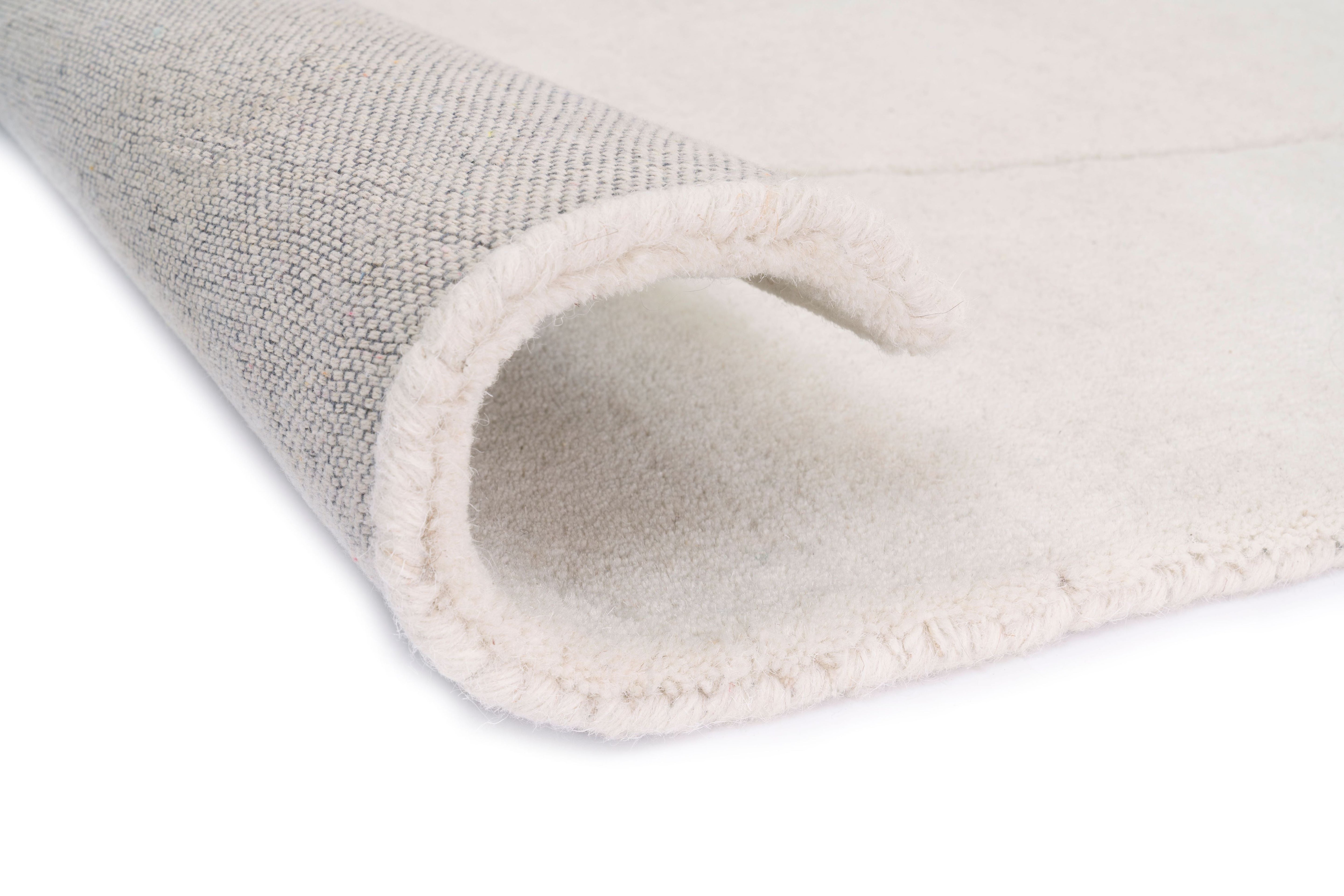 Bordure de tapis beige clair, finition texturée. Le dessous est gris clair