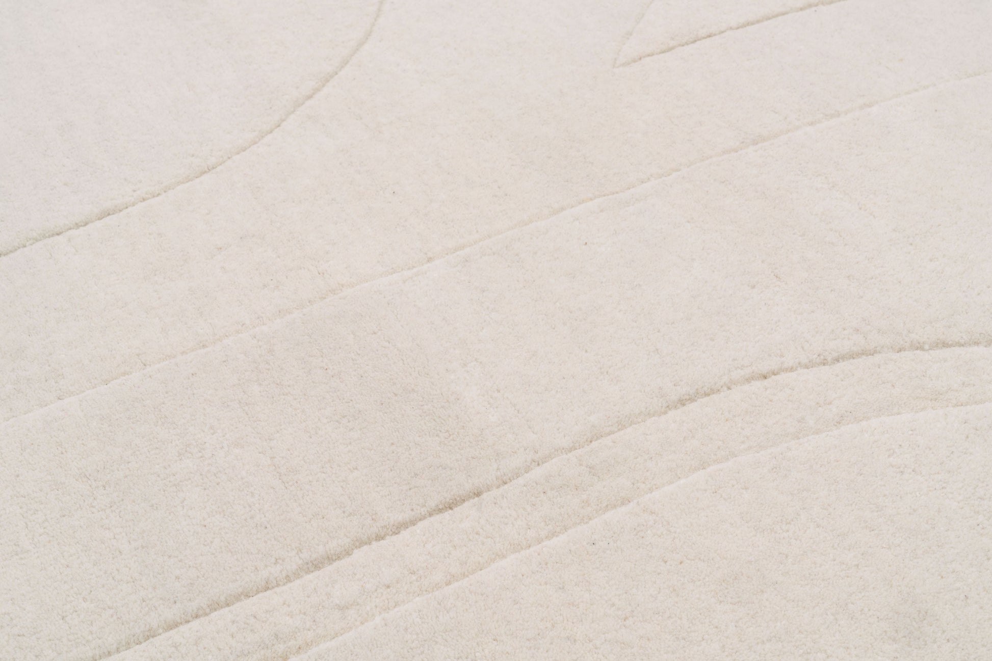 Détail texture du tapis Valanga en laine, fait main, de forme rectangulaire. Gros plan sur les fibres et le tissage clair.