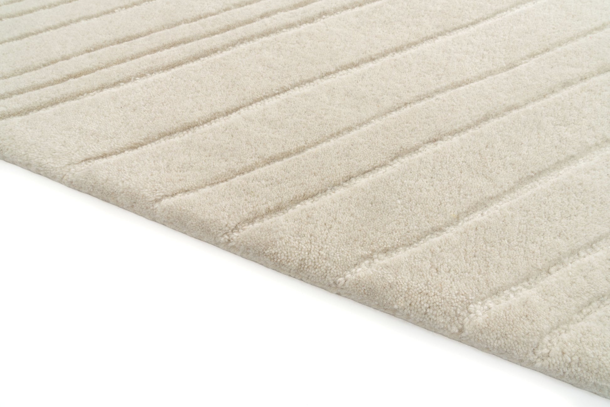 Tapis rectangulaire beige clair avec finition côtelée. Texture douce, ambiance chaleureuse