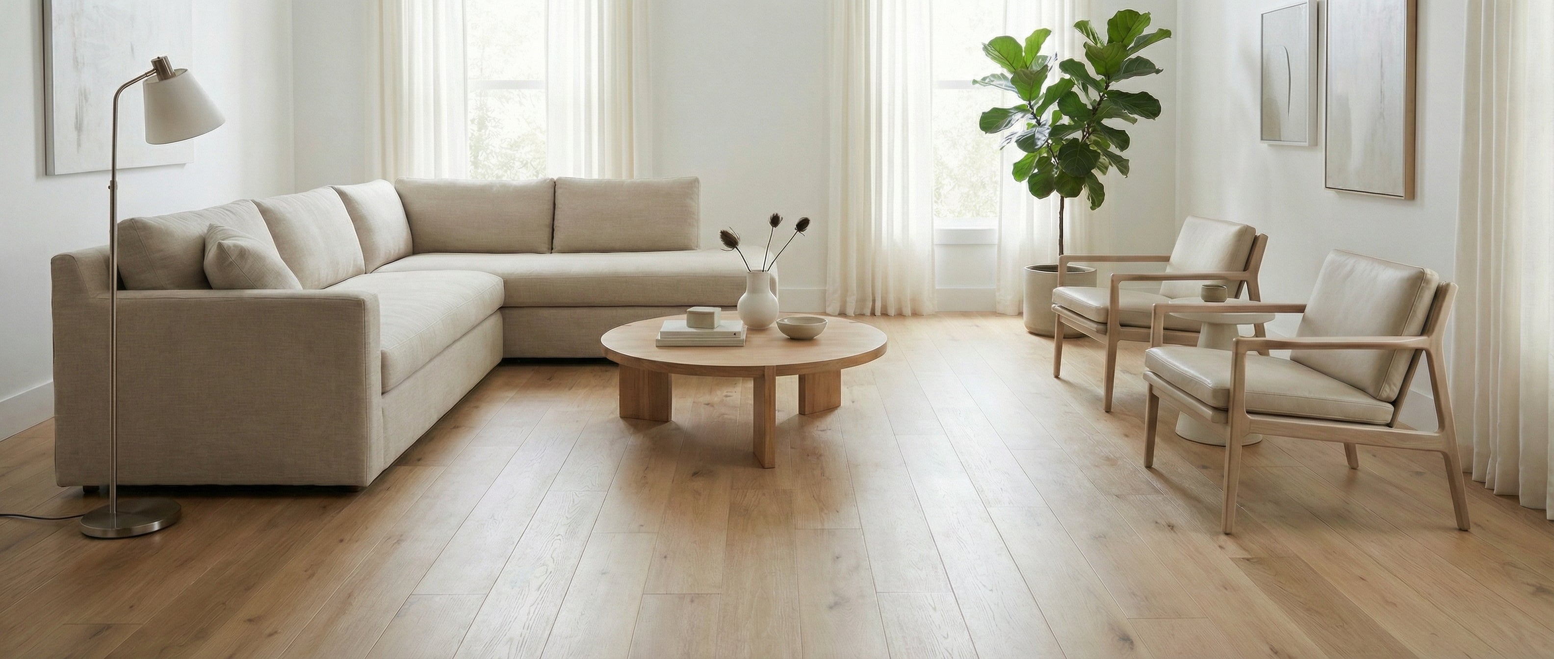 Pièce lumineuse et aérée, murs blancs, canapé beige, parquet clair. Espace vide pour tapis, ambiance minimaliste