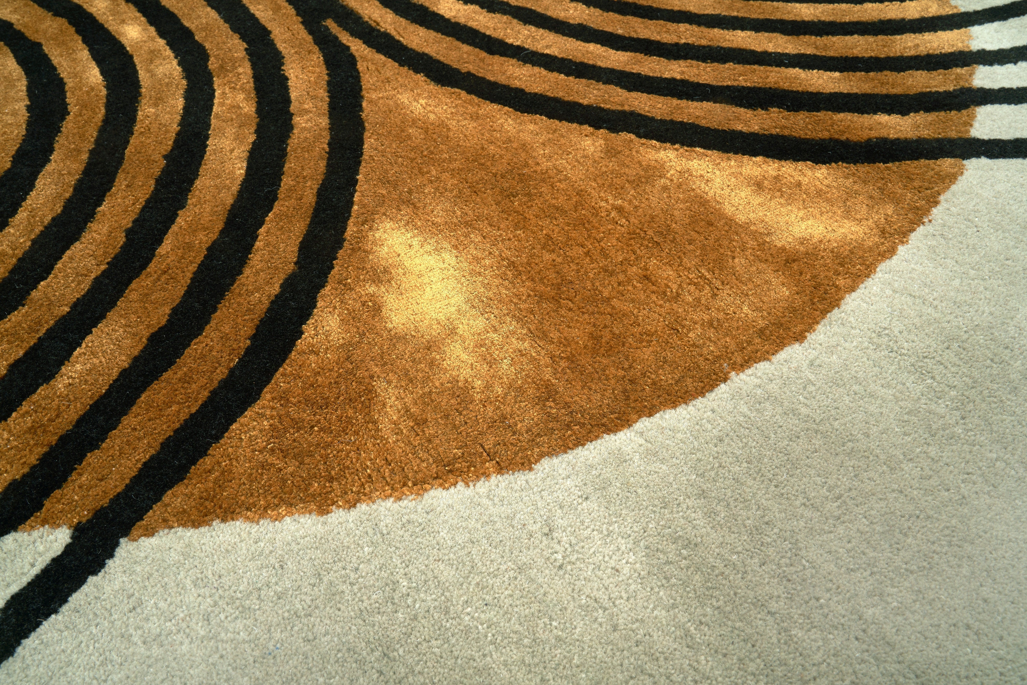 Tapis rond, tissage touffeté. Relief marqué, couleur marron et noir. Pièce beige