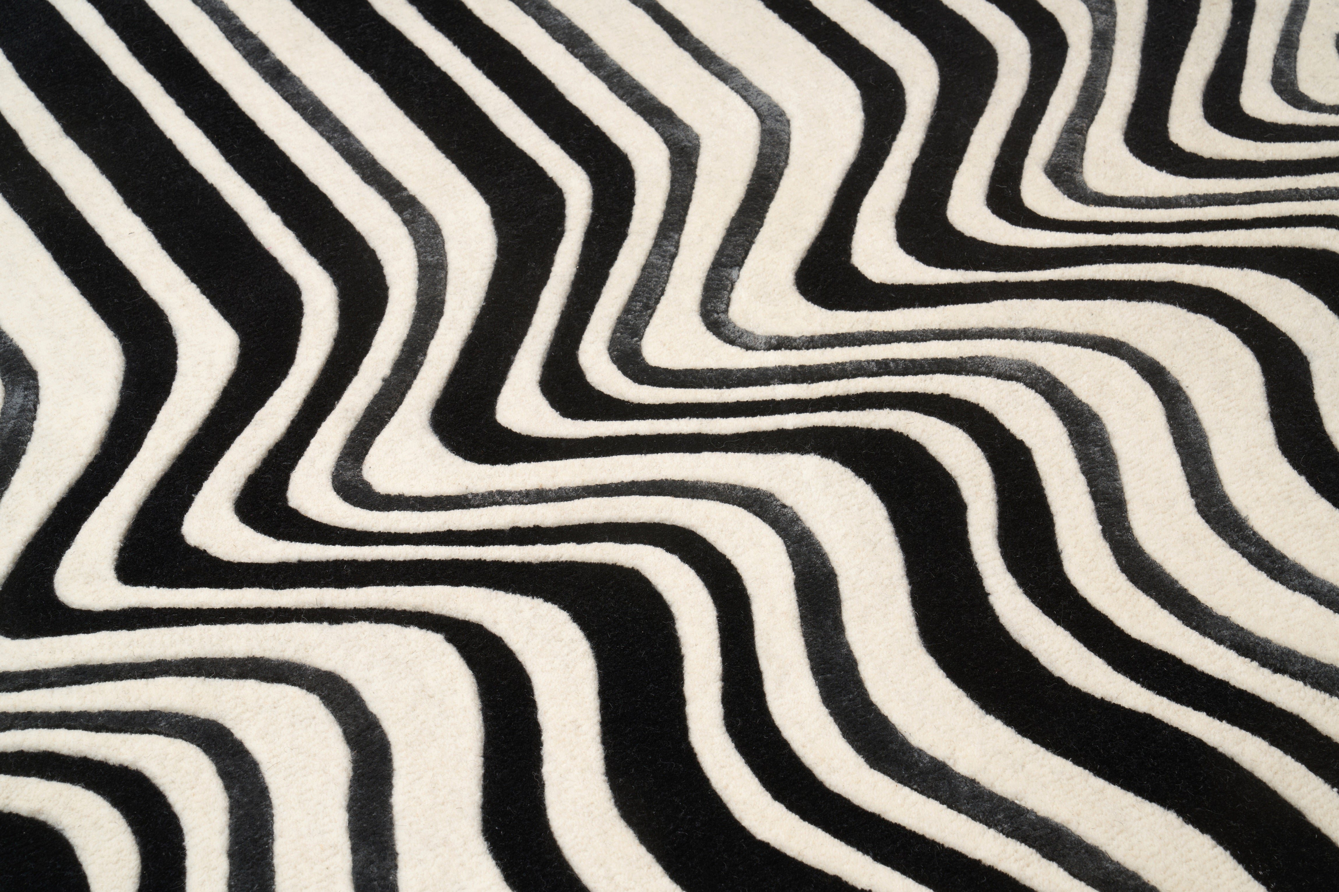 Tapis de type tissage, noir et blanc. Relief ondulé, pièce ovale