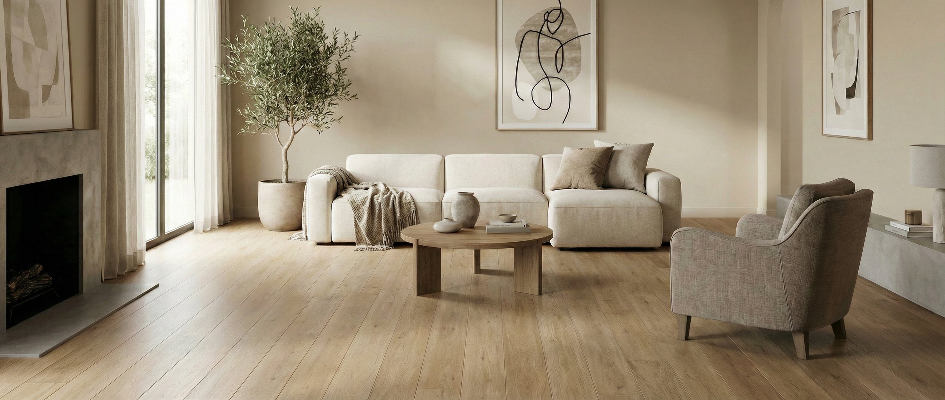 Pièce lumineuse, tons neutres, parquet clair. Canapé, fauteuil, table basse ronde. Espace vide pour un tapis, ambiance