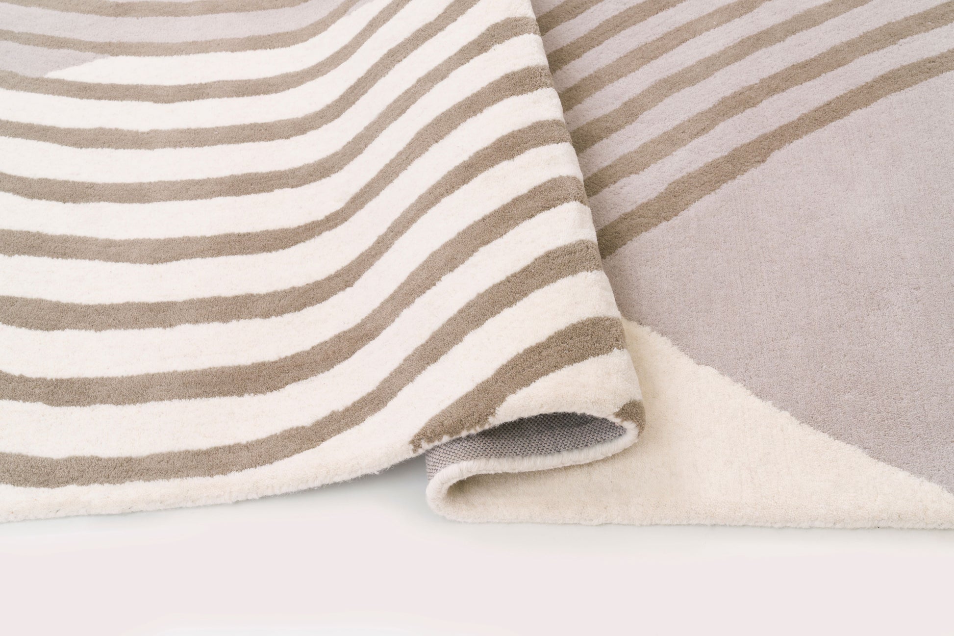 Tapis rectangulaire, densité apparente, moelleux et confortable. Rayures taupe et blanc cassé. Ambiance douce