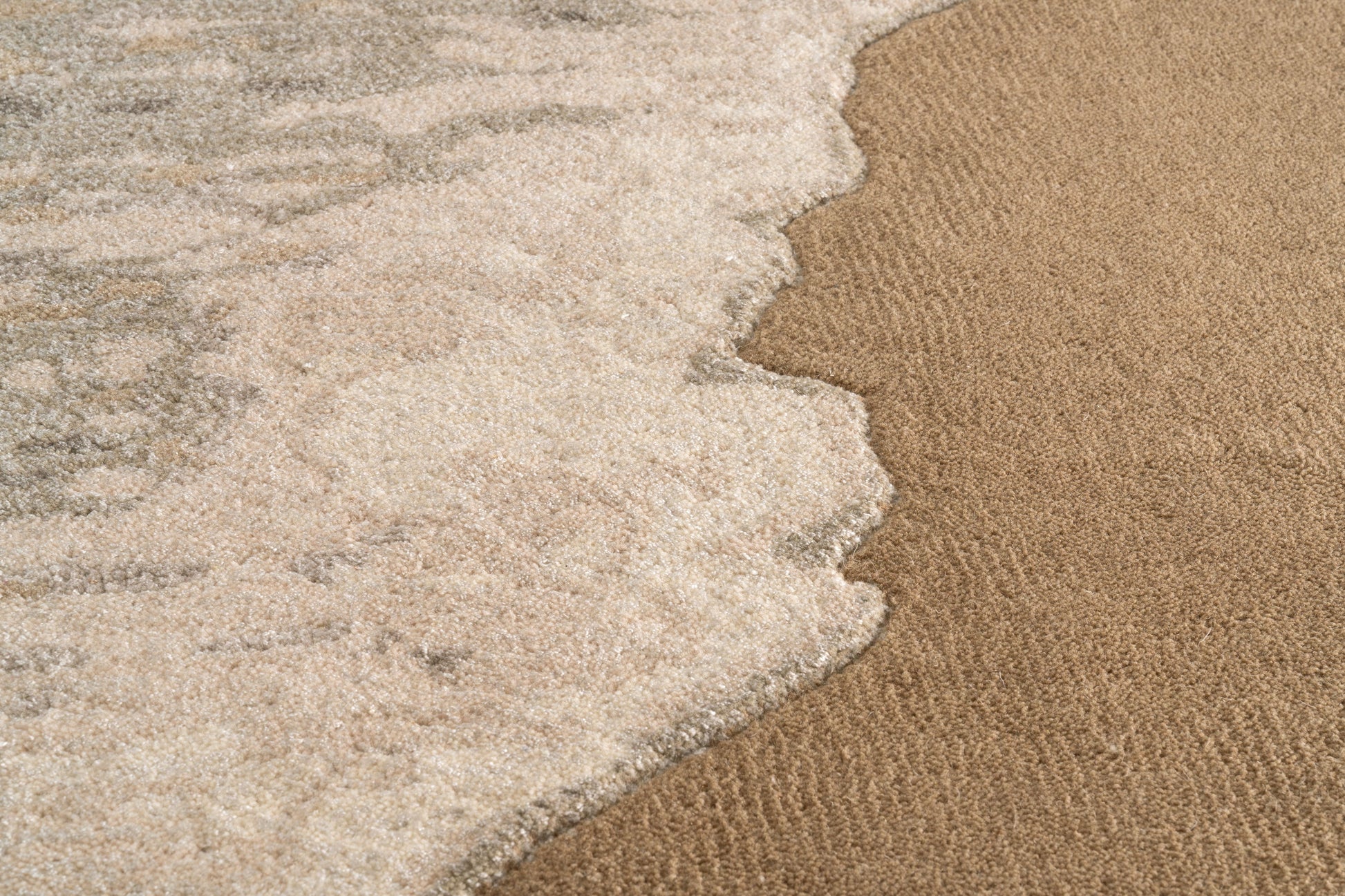 Tapis rectangulaire. Tissage dense, relief subtil. Aspect tactile doux, couleurs beige et marron clair