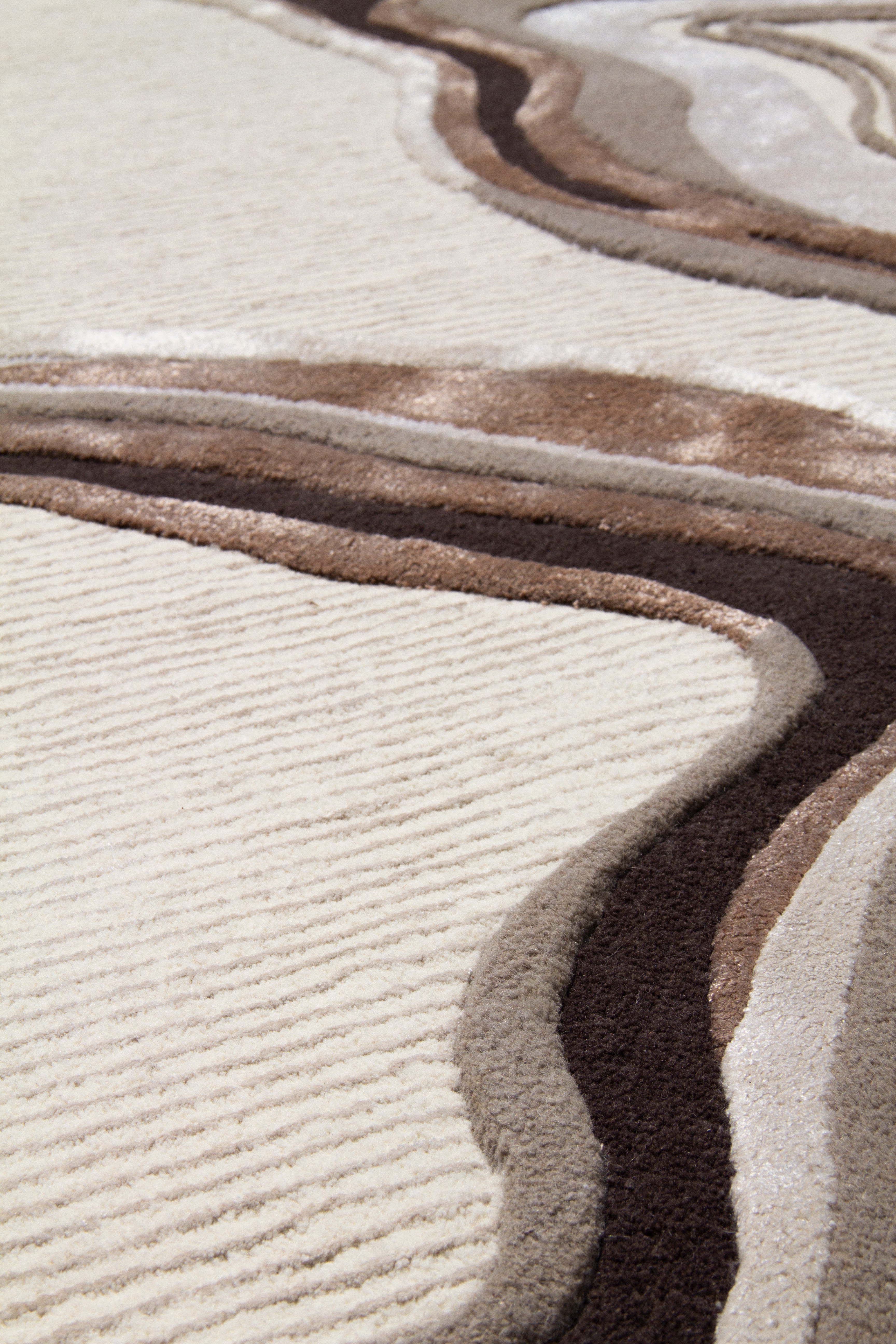 Tapis rectangulaire beige à motifs ondulés bruns. Tissage à relief, aspect tactile doux et texturé