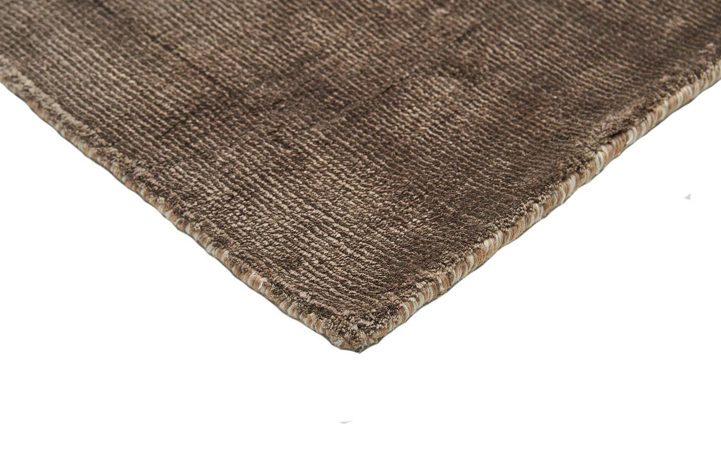 Bordure de tapis avec une finition cousue. Couleurs taupe et beige clair. Le tapis est de forme rectangulaire