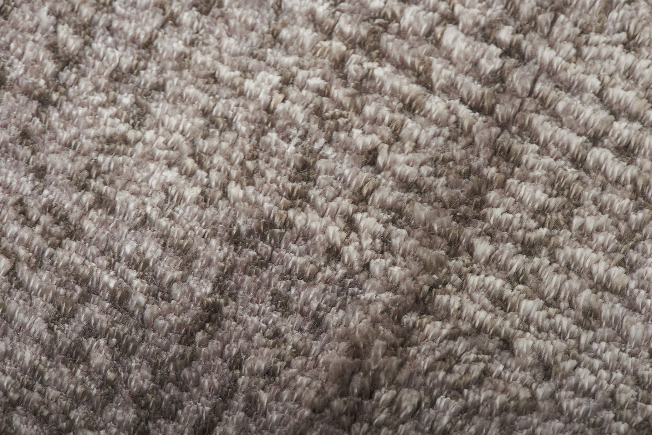 Tapis à poils longs taupe, tissage texturé. Relief prononcé, aspect tactile doux et moelleux