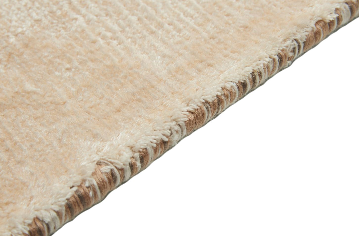 Tapis épais et moelleux, couleur taupe. Confort apparent. Bordure tressée. Ambiance chaleureuse
