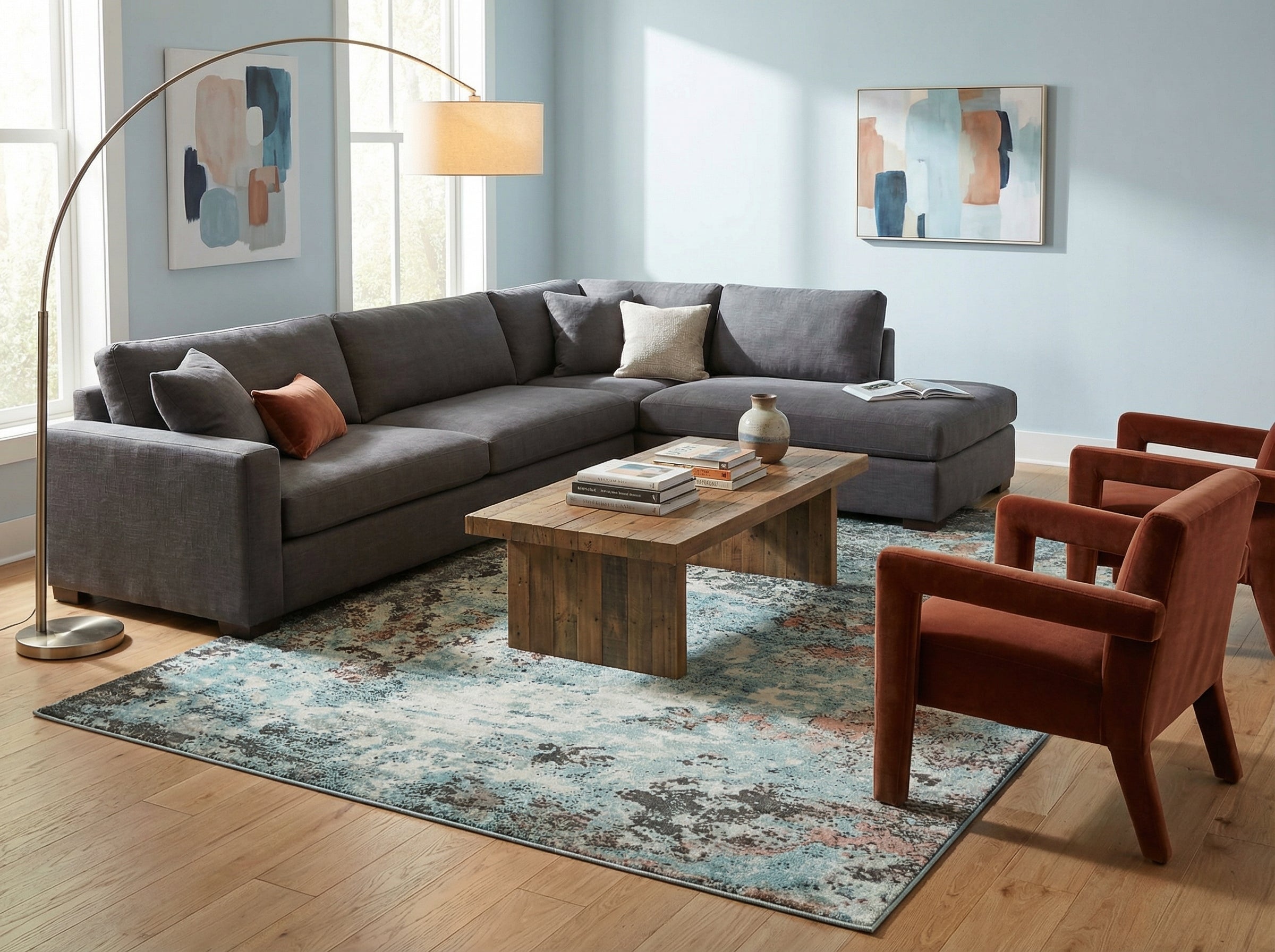 Salon moderne, canapé gris, fauteuils rouille. Tapis rectangulaire bleu/gris, bois clair. Ambiance chaleureuse, style déco