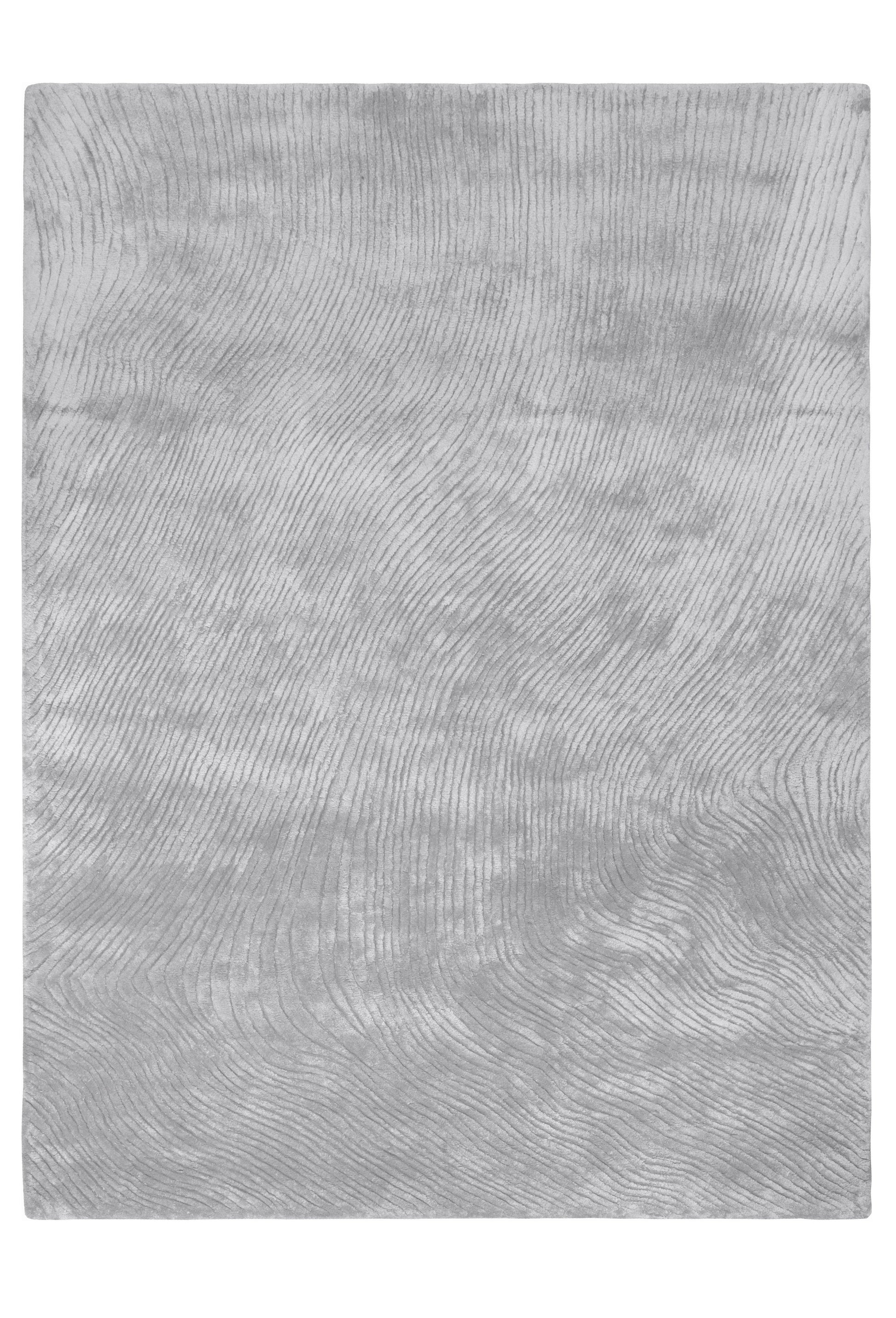 Tapis rectangulaire gris argenté avec un motif de lignes ondulées, créant une ambiance douce et moderne