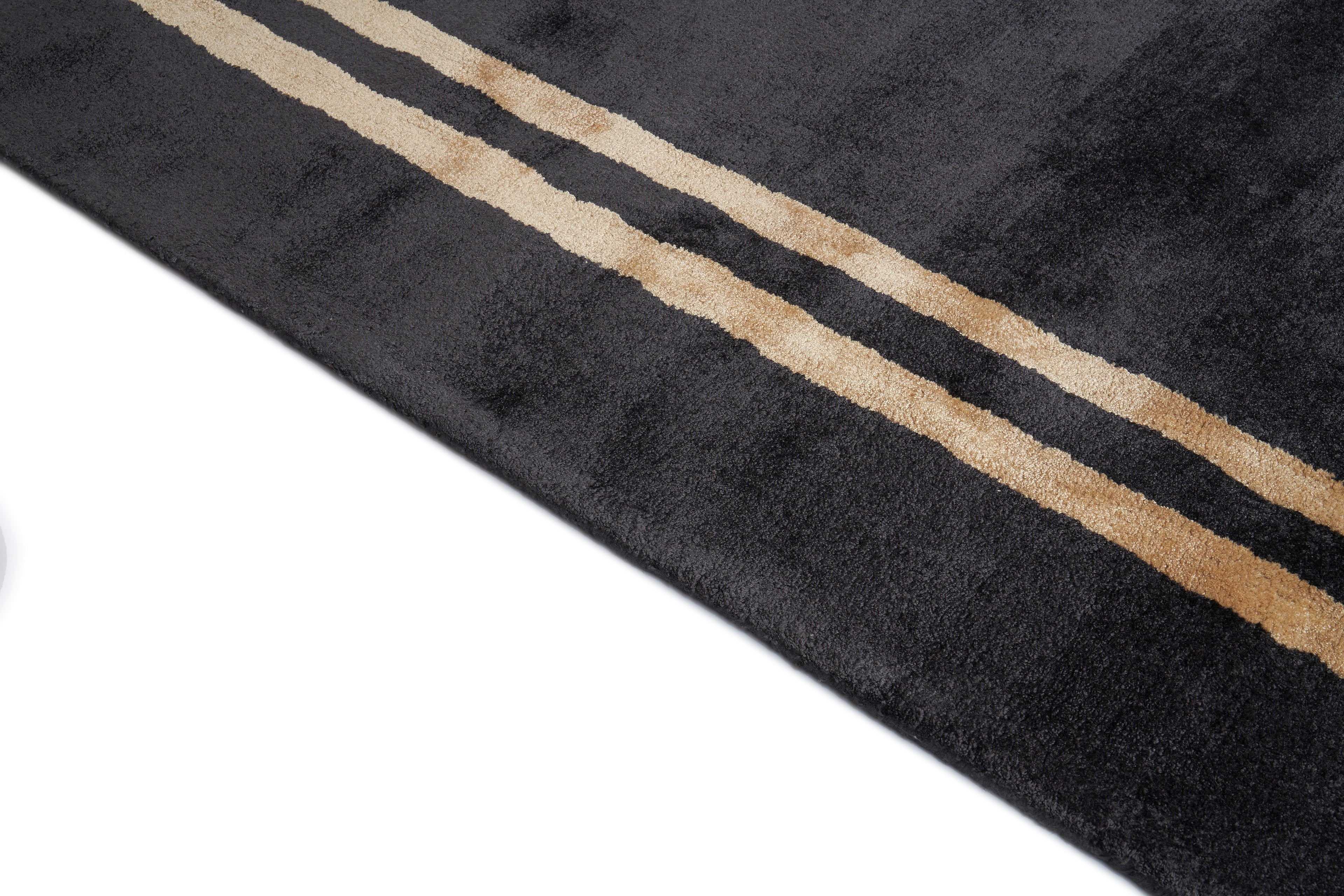 Tapis rectangulaire noir avec deux bandes beiges. Tissage touffeté, relief texturé, aspect tactile doux