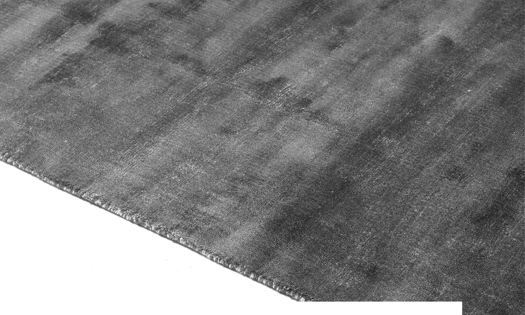 Tapis rectangulaire gris. Densité et moelleux apparents. Confort visuel. Ambiance feutrée
