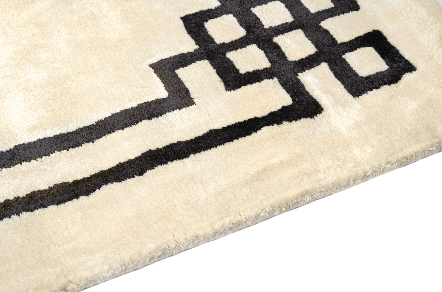Tapis rectangulaire ivoire avec bordure noire géométrique. Finition de qualité, ambiance moderne