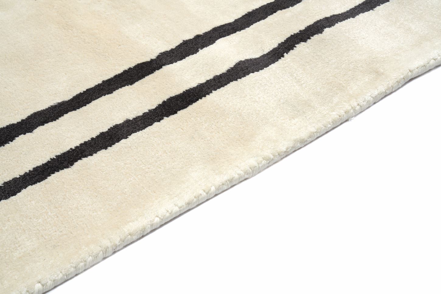 Tapis rectangulaire, ivoire et noir. Densité et moelleux apparents. Confort visuel
