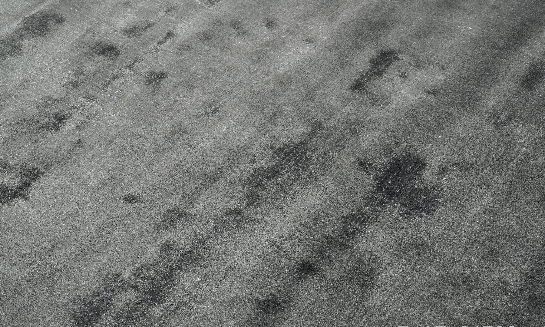 Détail texture du tapis gris en acier uni, fait main. Matière viscose. Vue rapprochée des fibres et du tissage. Forme rectangulaire.