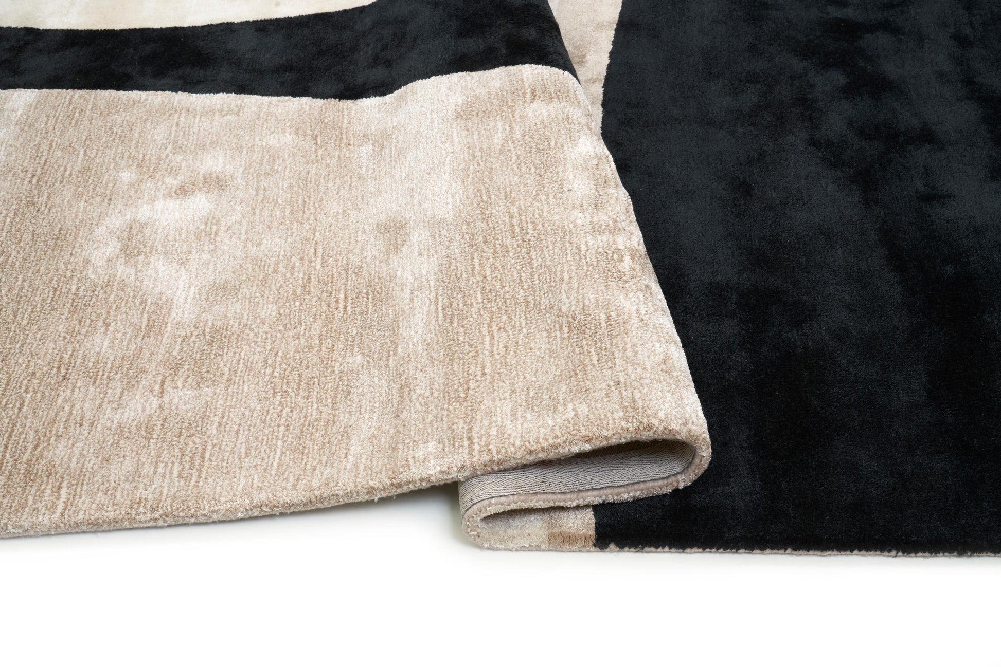 Tapis rectangulaire, dense et moelleux. Beige et noir, confort apparent