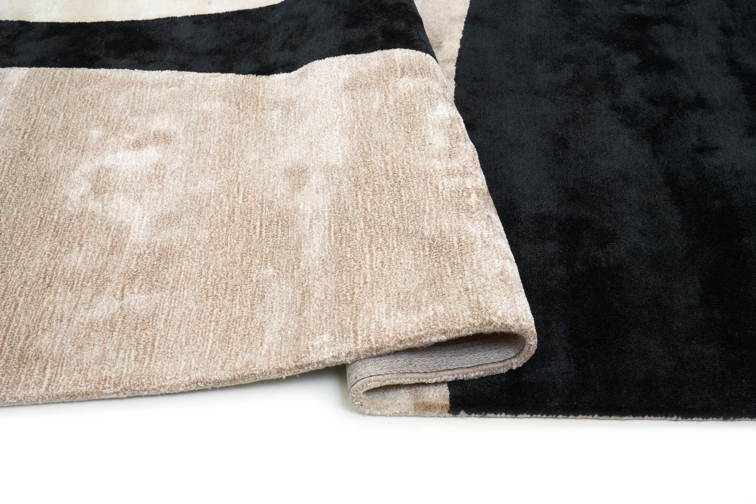 Tapis rectangulaire, dense et moelleux. Beige et noir, confort apparent