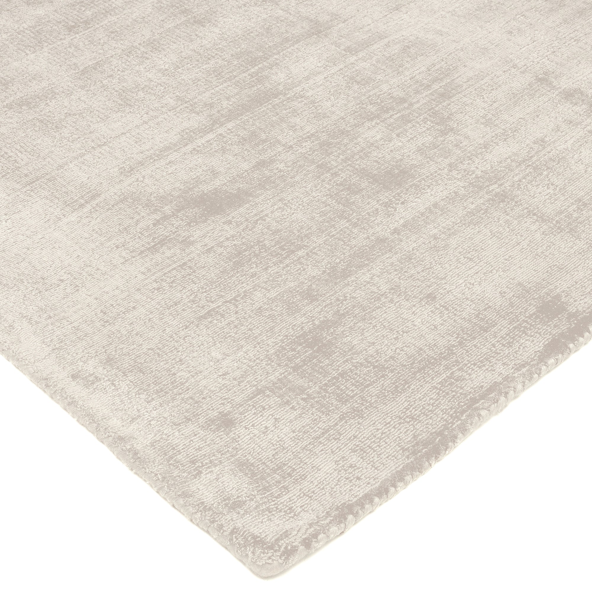 Bordure de tapis en beige clair, finition simple. Tissage texturé, ambiance neutre. Forme rectangulaire