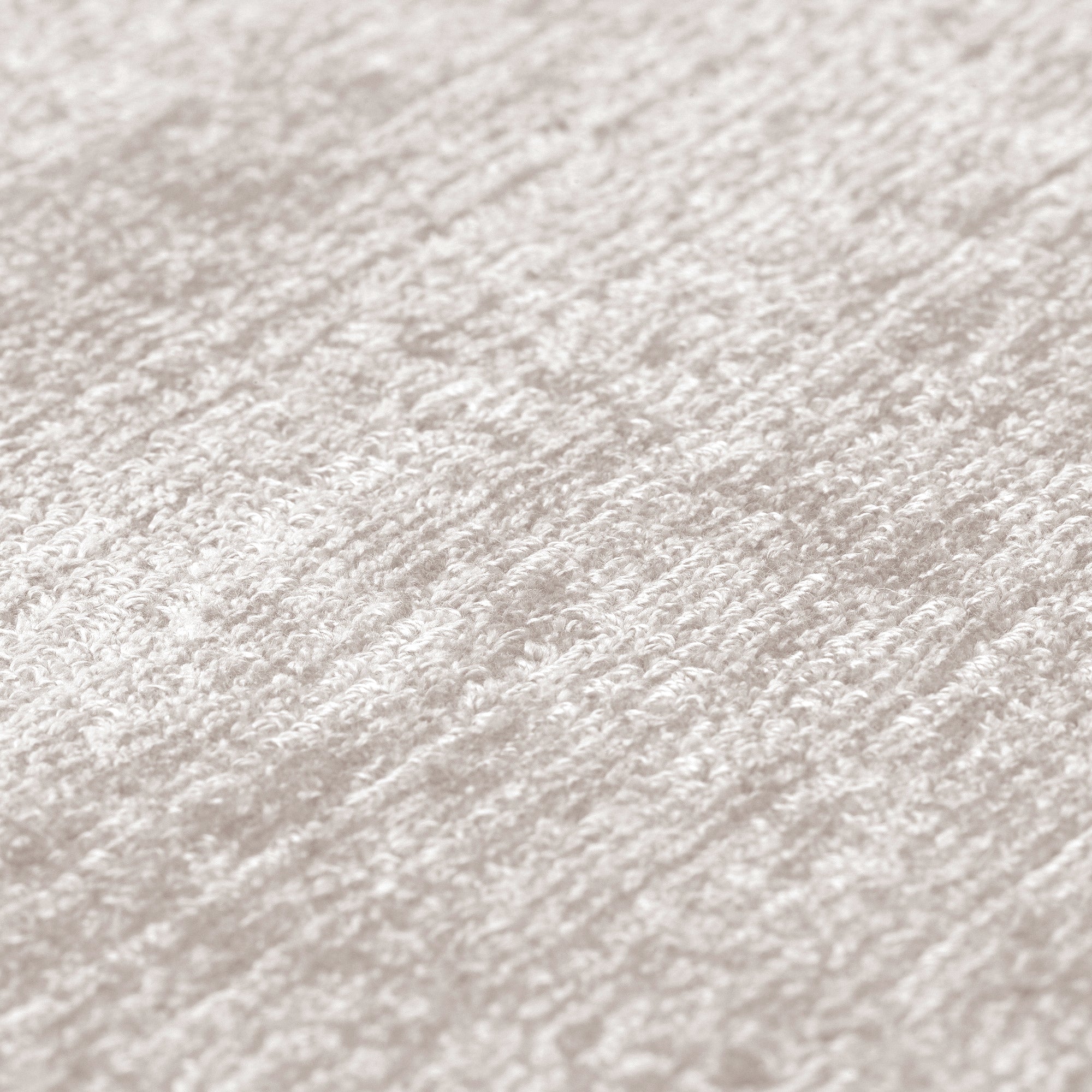 Tapis à tissage serré, relief texturé. Aspect tactile doux, couleurs neutres et ambiance chaleureuse. Forme rectangulaire