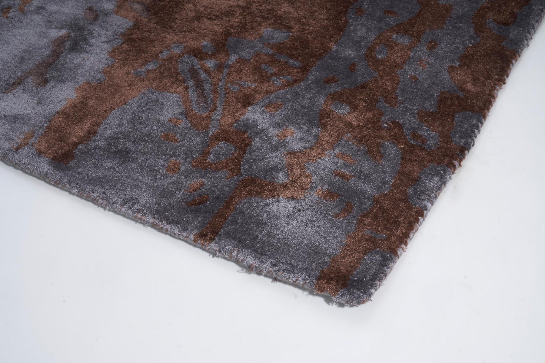 Bordure de tapis avec des fils gris et marron. Finition de qualité, style abstrait