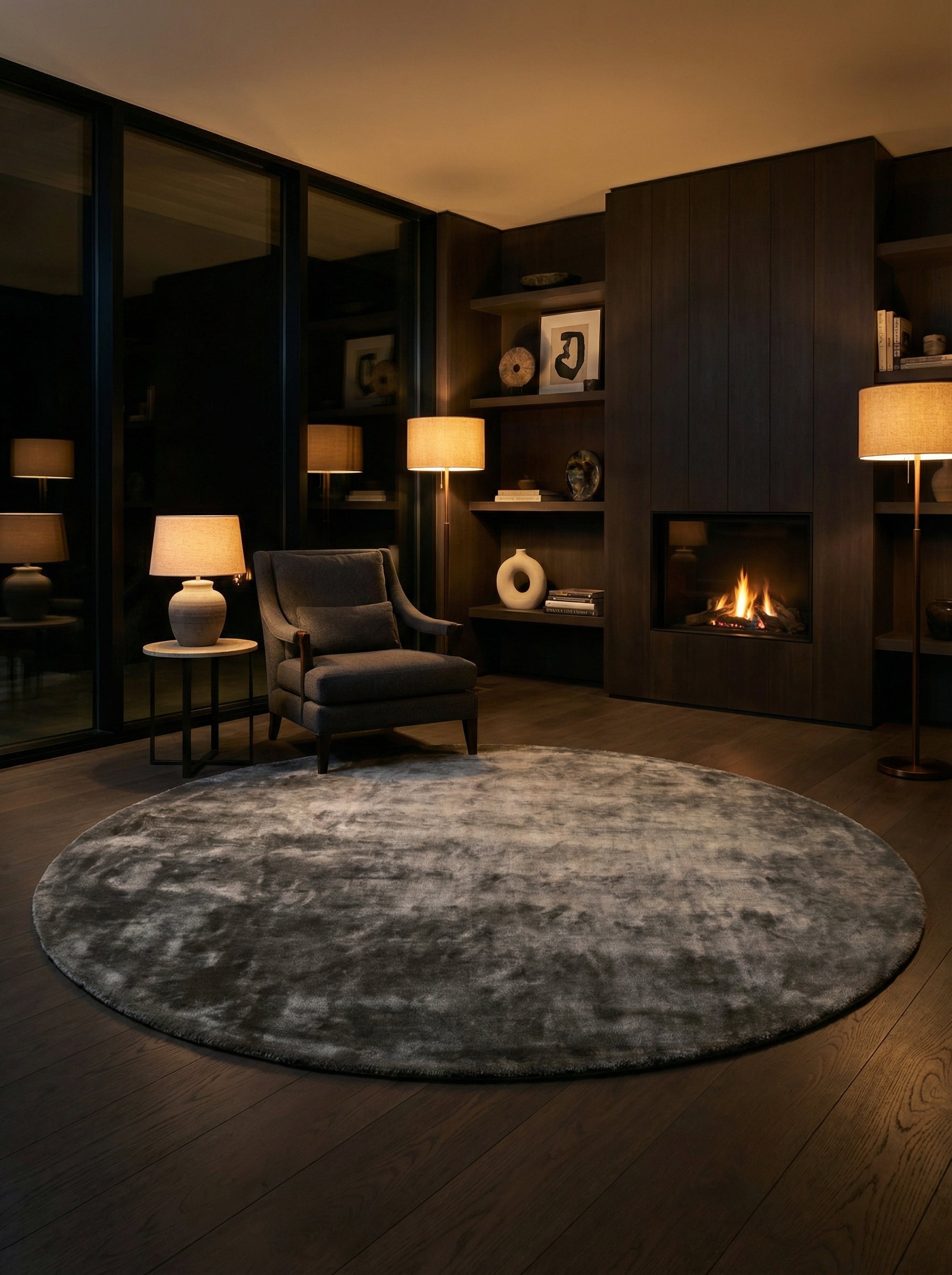 Tapis rond gris, pièce éclairée de lumière douce. Chaleur émise par le foyer. Ambiance soir