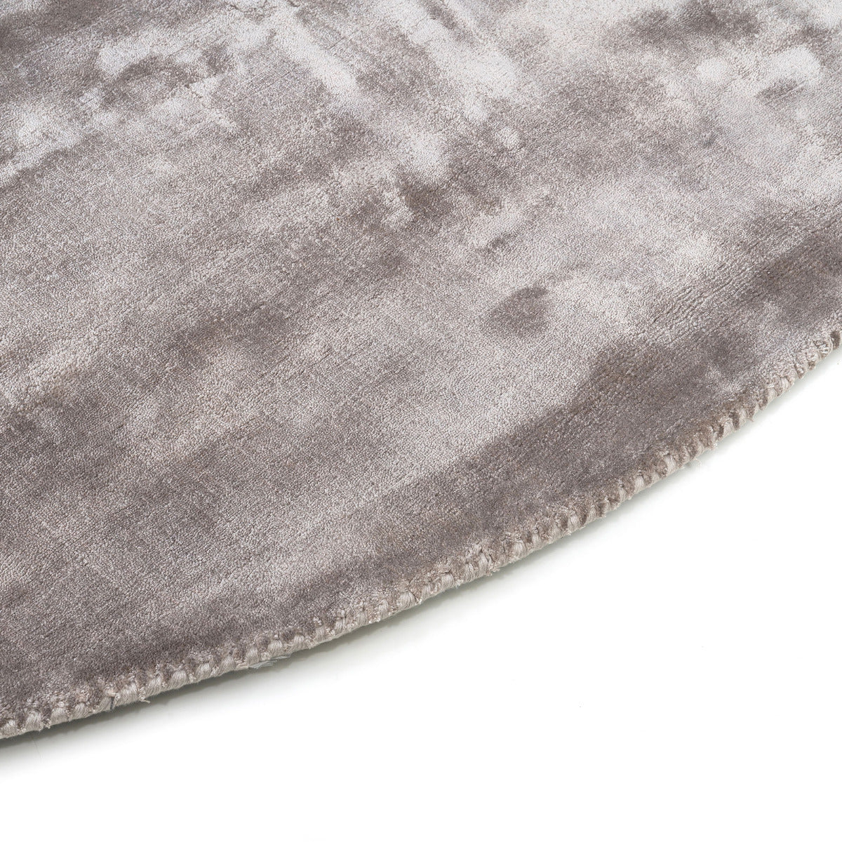Bordure de tapis cousue, finition soignée. Tapis rond gris, qualité douce, aspect velouté