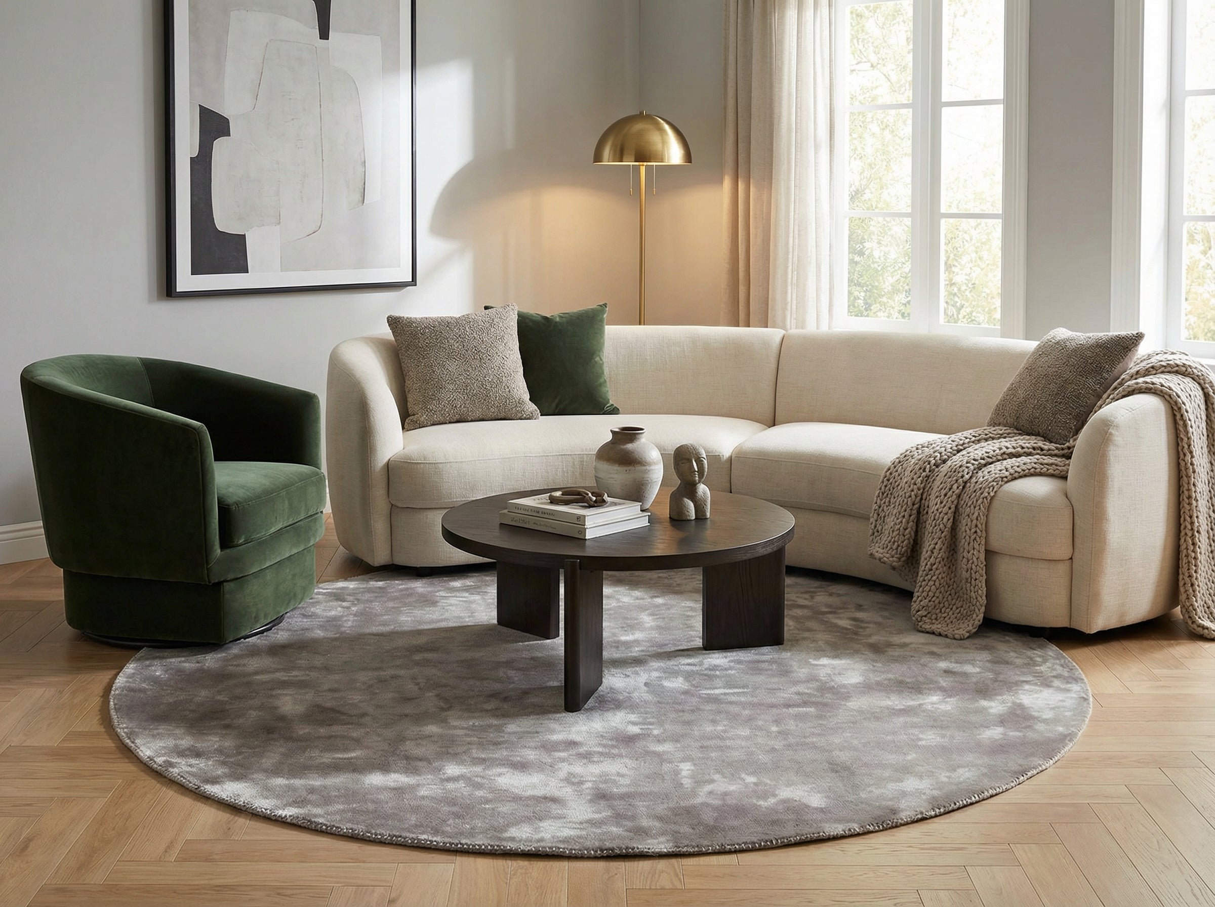 Style déco contemporain, ambiance cosy. Pièce avec tapis rond gris en viscose, canapé clair, fauteuil vert