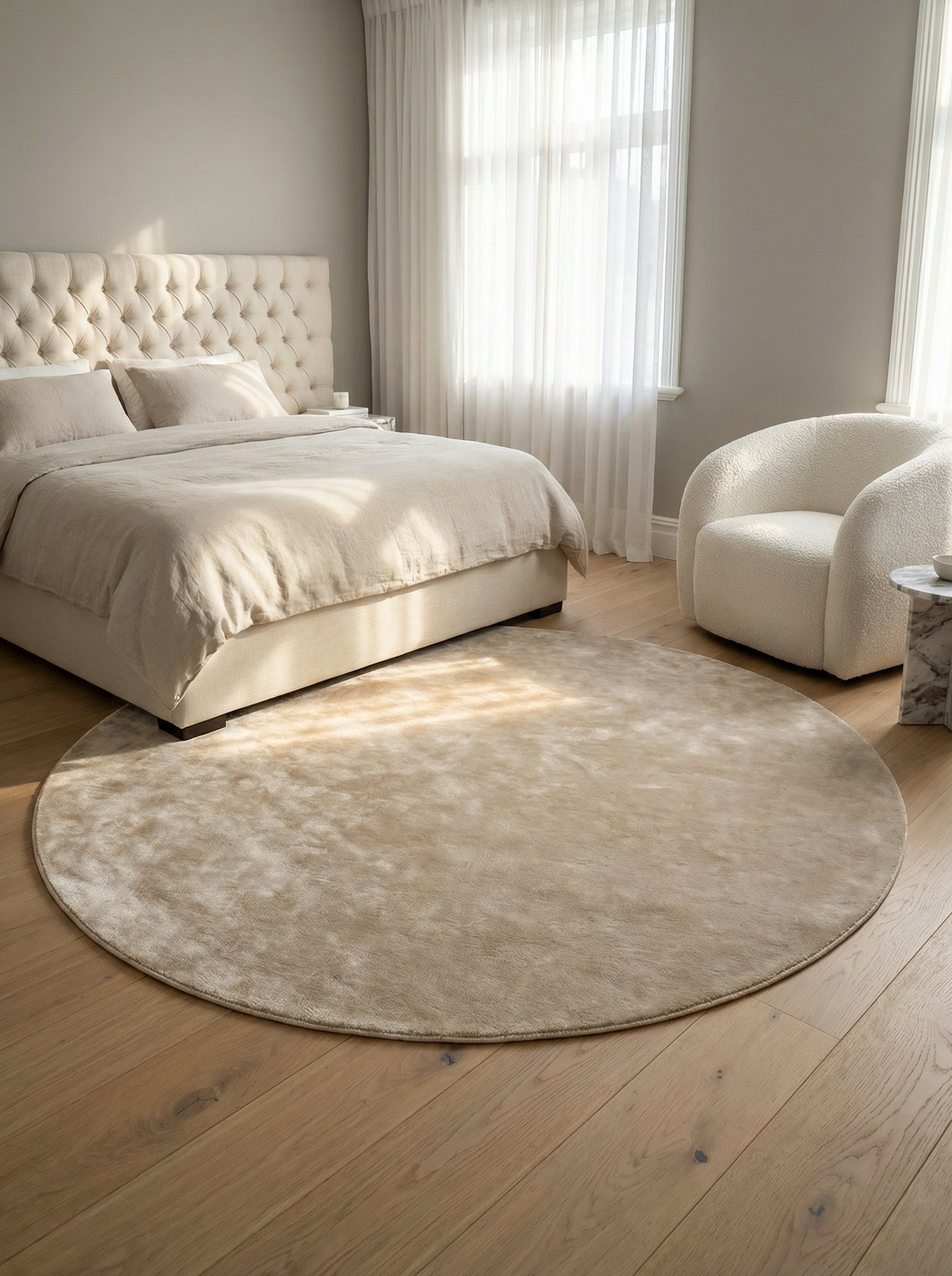 Tapis rond beige dans une chambre. Harmonie des couleurs sable et bois clair. Ambiance douce et chaleureuse. Style épuré