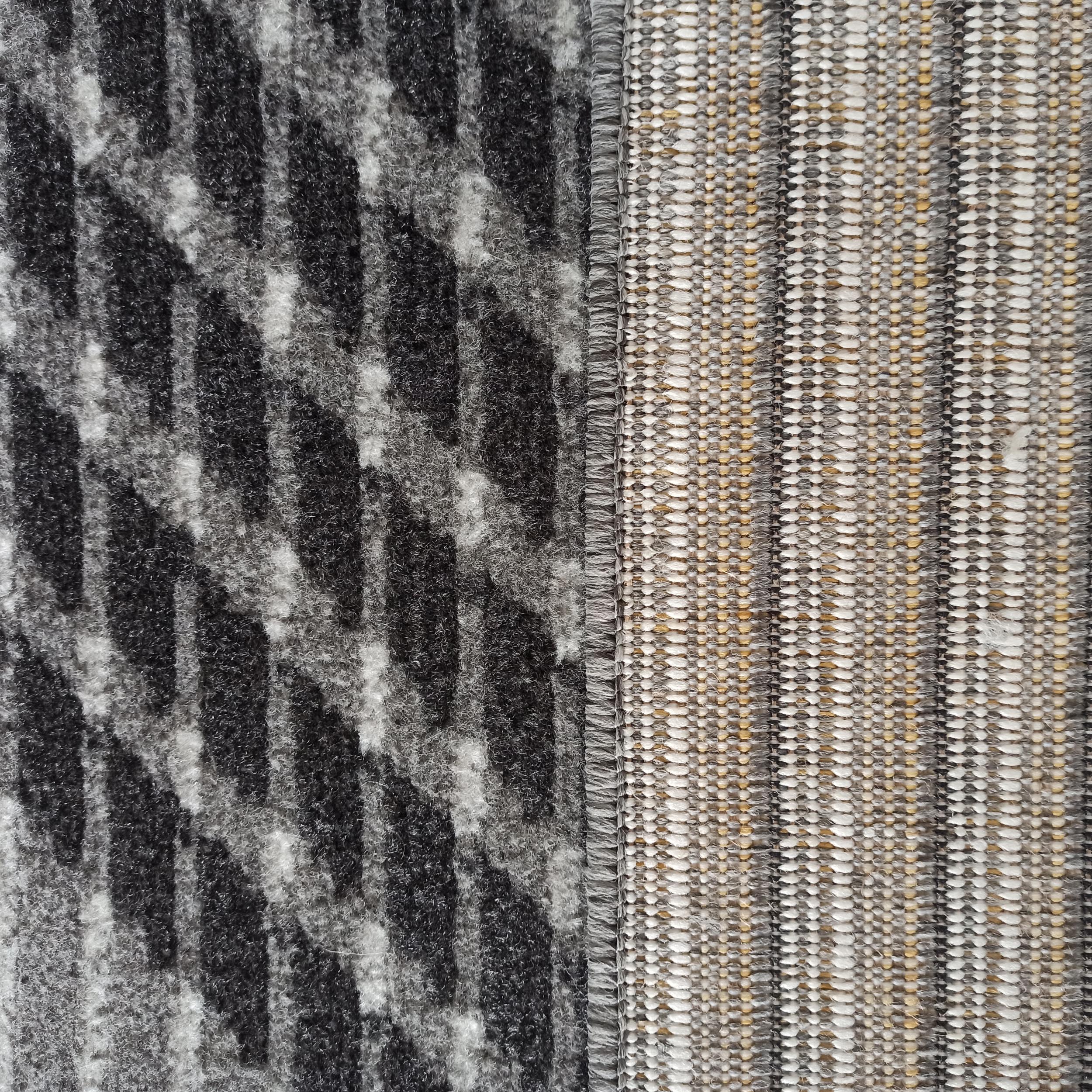 Tapis au motif abstrait noir et gris sur une texture à poils longs, juxtaposé à un tissage rayé beige, gris et blanc