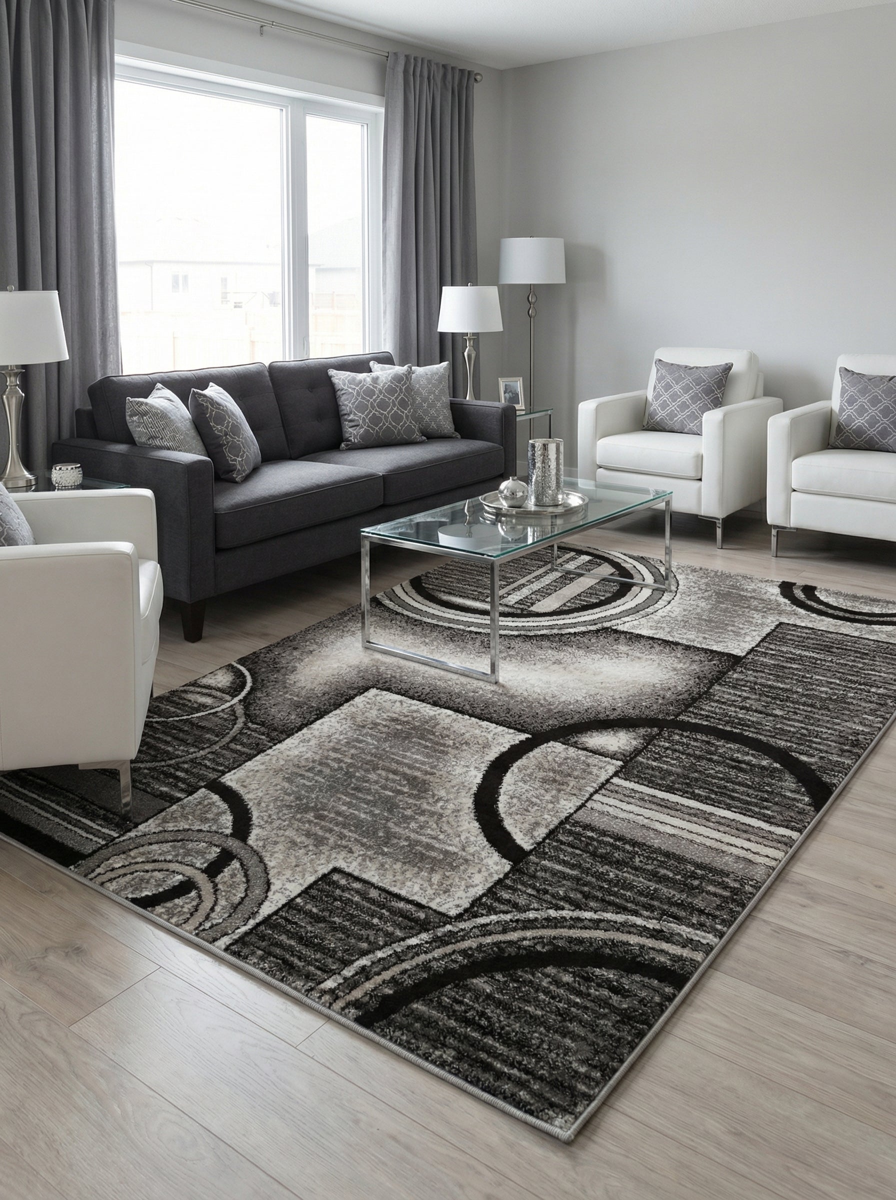 Tapis rectangulaire aux motifs géométriques de cercles et de bandes en nuances de gris, noir et blanc, posé dans un salon moderne