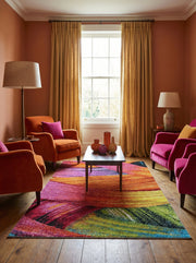 Tapis rectangulaire texturé aux motifs abstraits et colorés en fuchsia, orange, jaune, vert et bleu sur un parquet de salon