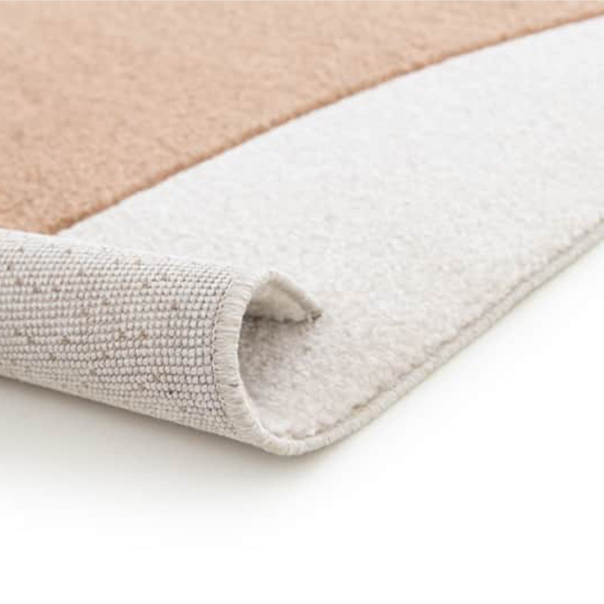 Gros plan sur un tapis bicolore aux poils doux, beige et blanc cassé. Un bord est roulé, révélant son envers gris clair tissé
