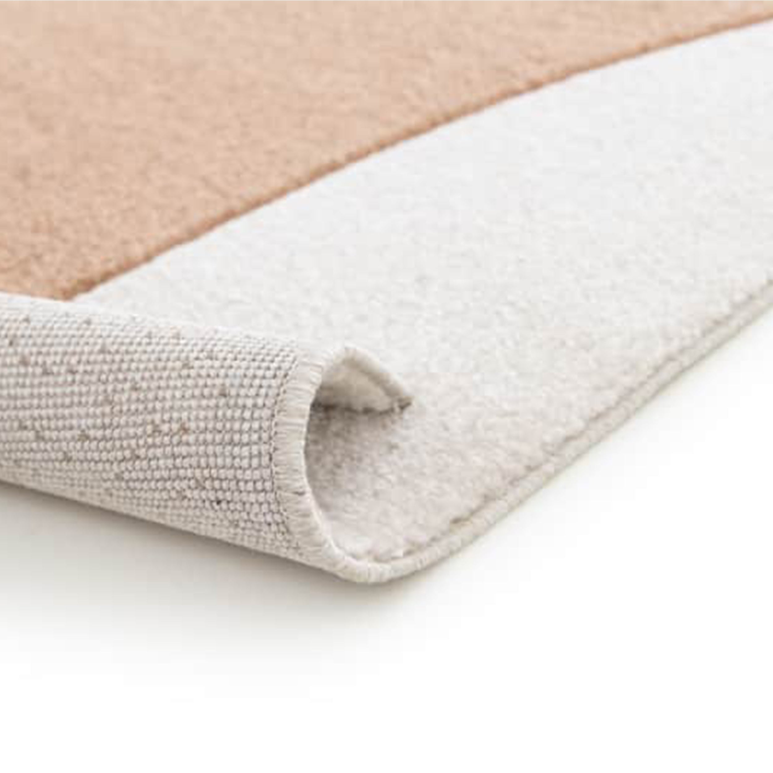 Gros plan sur un tapis bicolore aux poils doux, beige et blanc cassé. Un bord est roulé, révélant son envers gris clair tissé